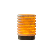 Alabaster striped table lamp emitting a warm glow on a surface.