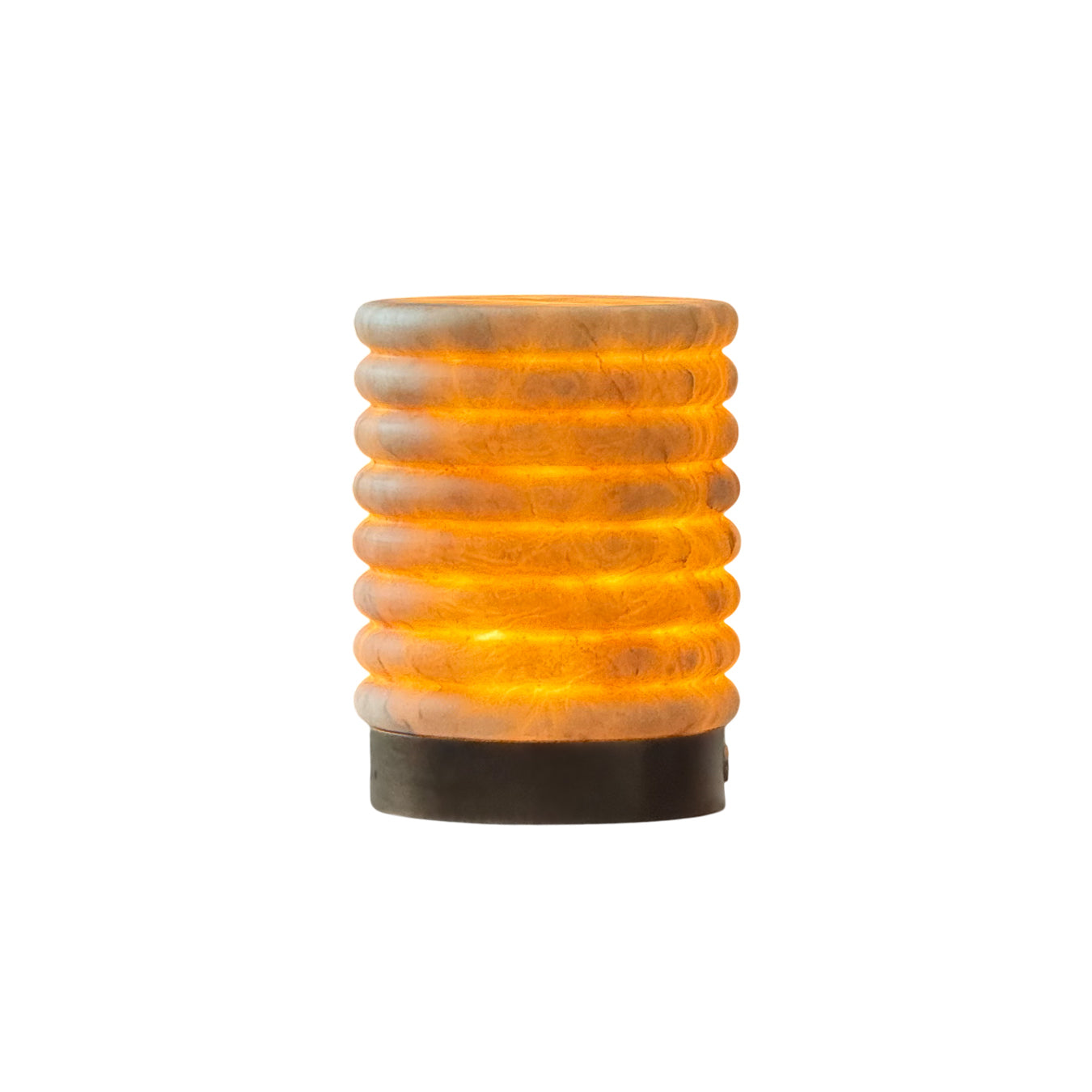 Alabaster striped table lamp emitting a warm glow on a surface.