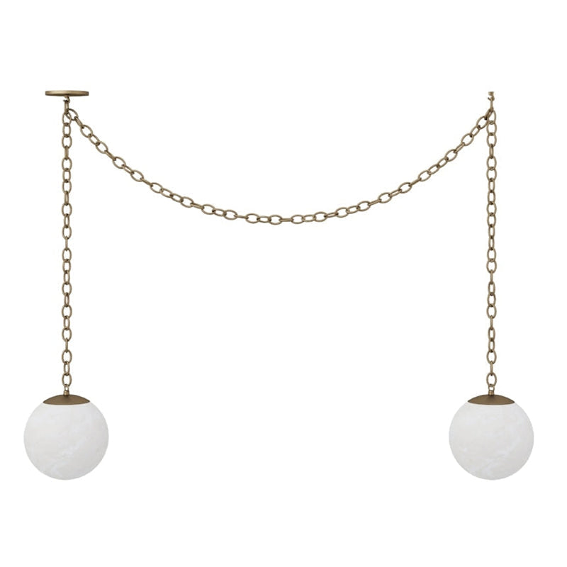 The Alabaster Swag Pendant Lamp with antique brass finish over a kitchen island.