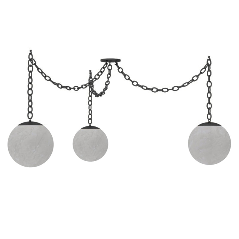 The Alabaster Swag Pendant Lamp casting a warm glow in an eclectic room.