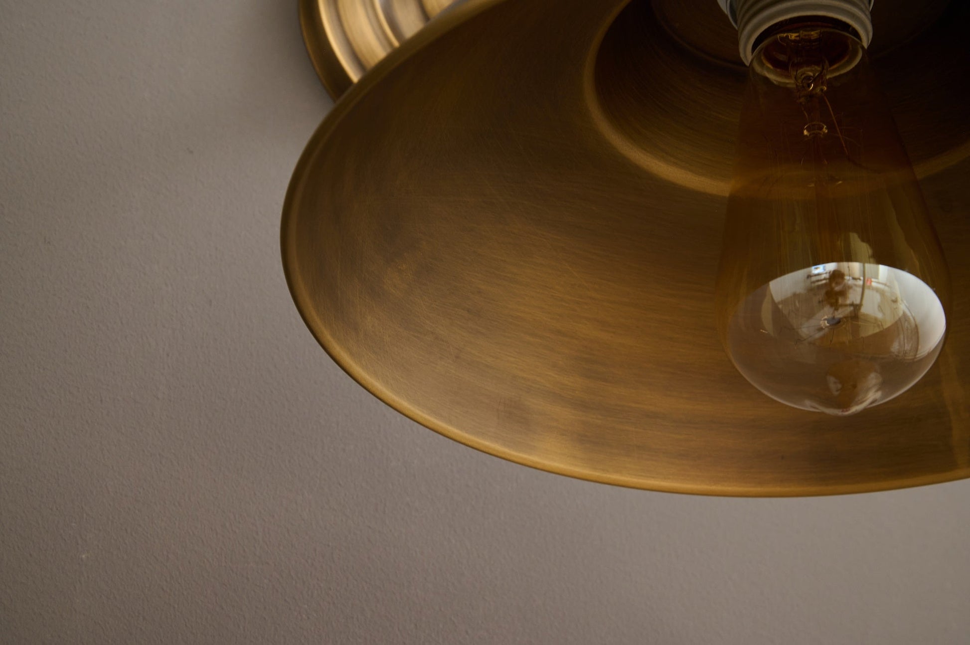 The Aldorno Wall Sconce against a light wall.