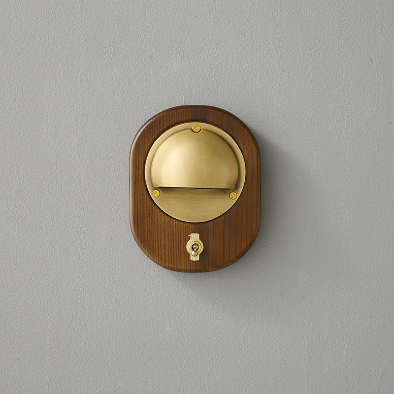 Close-up on the junction between the wood body and brass shade.