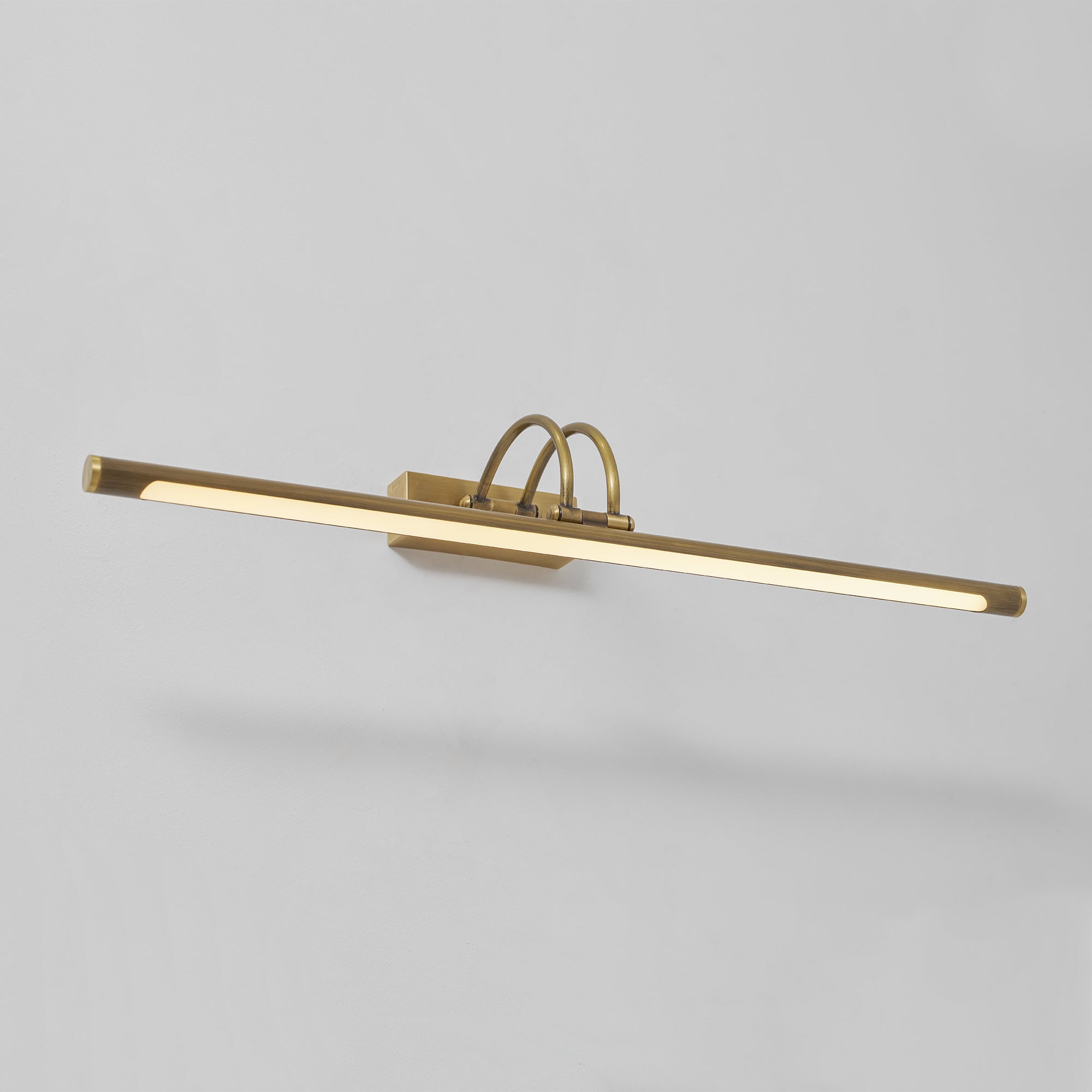 Lifestyle image of the Alton brass lamp over a bookshelf.
