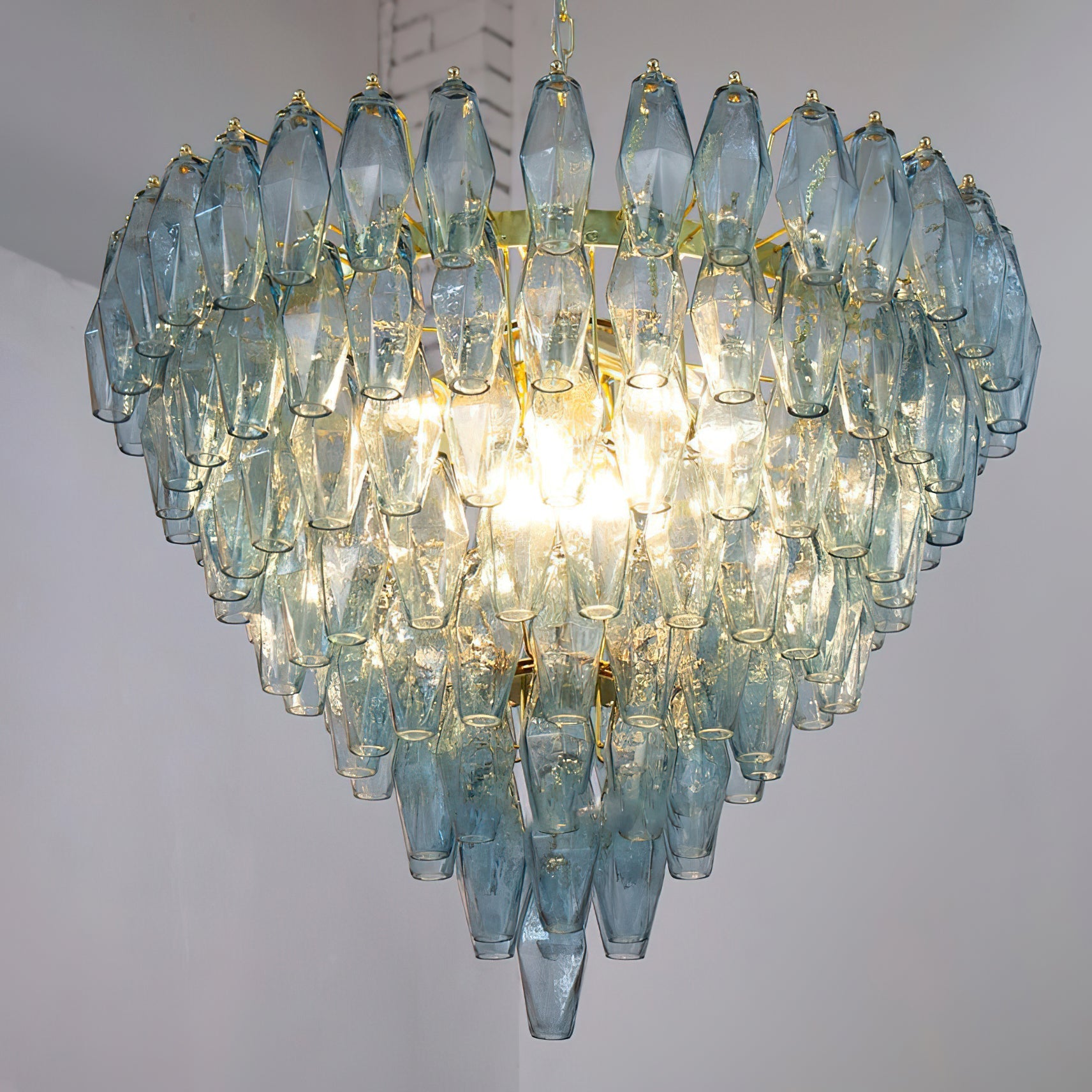 The Ametista Chandelier with clear glass prisms, illuminated and sparkling.