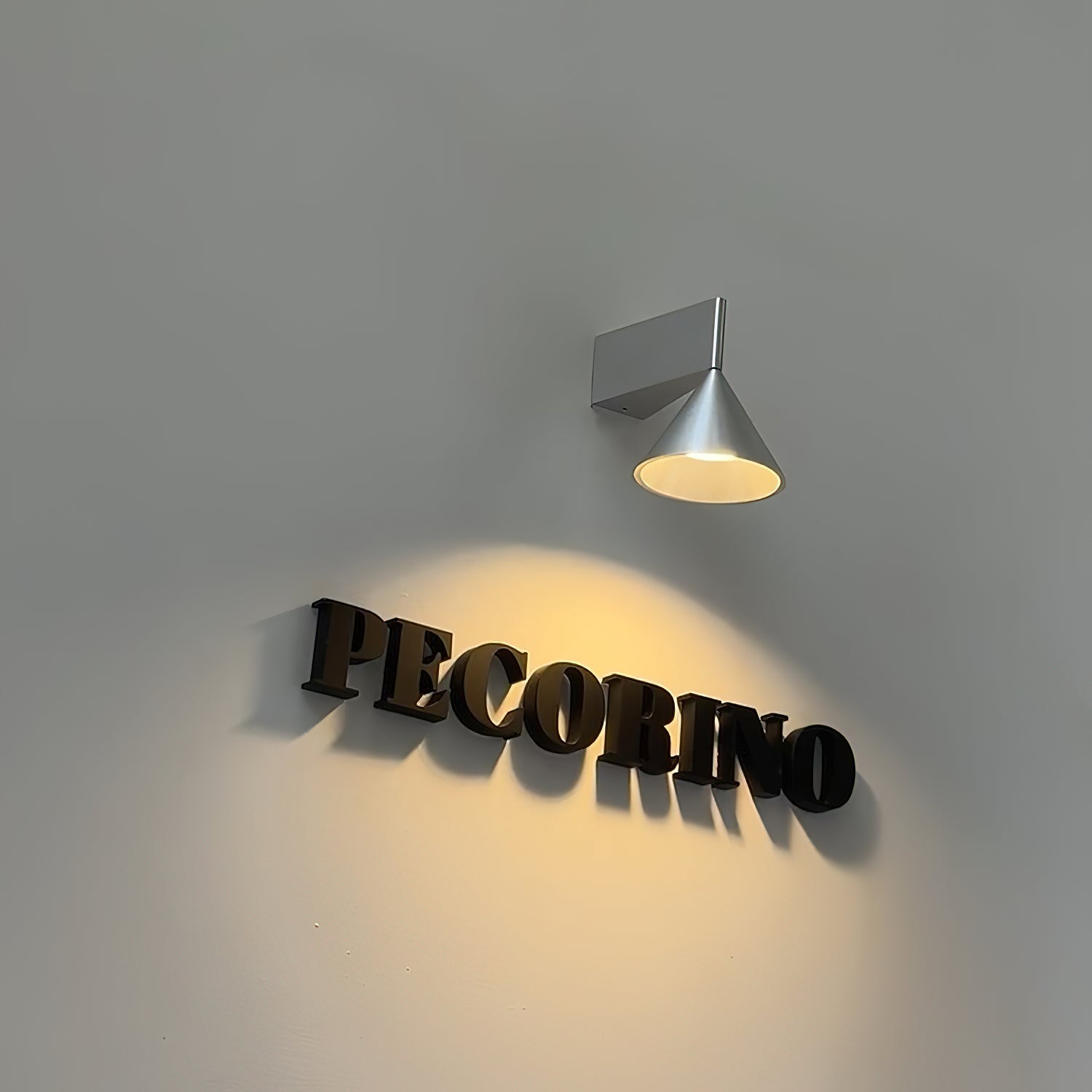 Apollo Wall Lamp shown with upward lighting effect on a wall.
