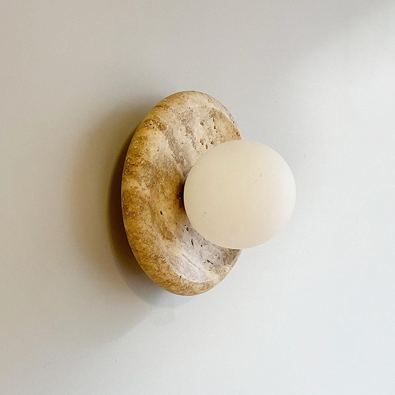 Angled view of the Apricity Travertine Wall Lamp displaying its form and dimensions.