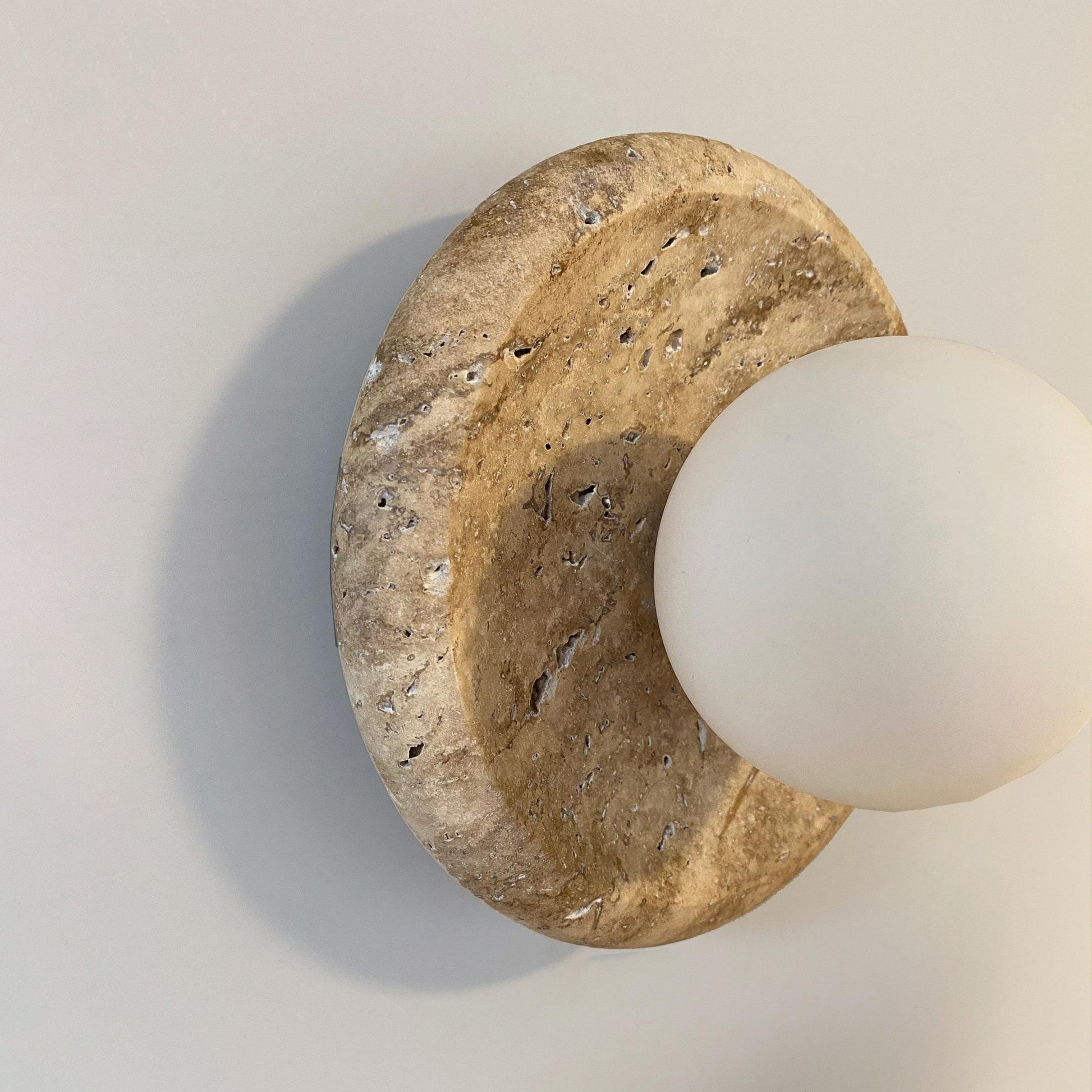 The Apricity Travertine Wall Lamp shown in the alternate white color option.
