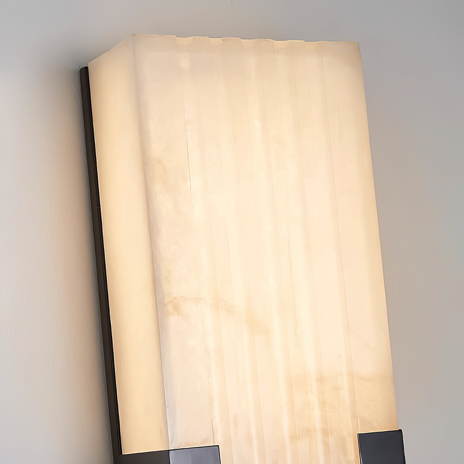 The alabaster shade of the Ariel Wall Lamp, unlit, showing its texture.