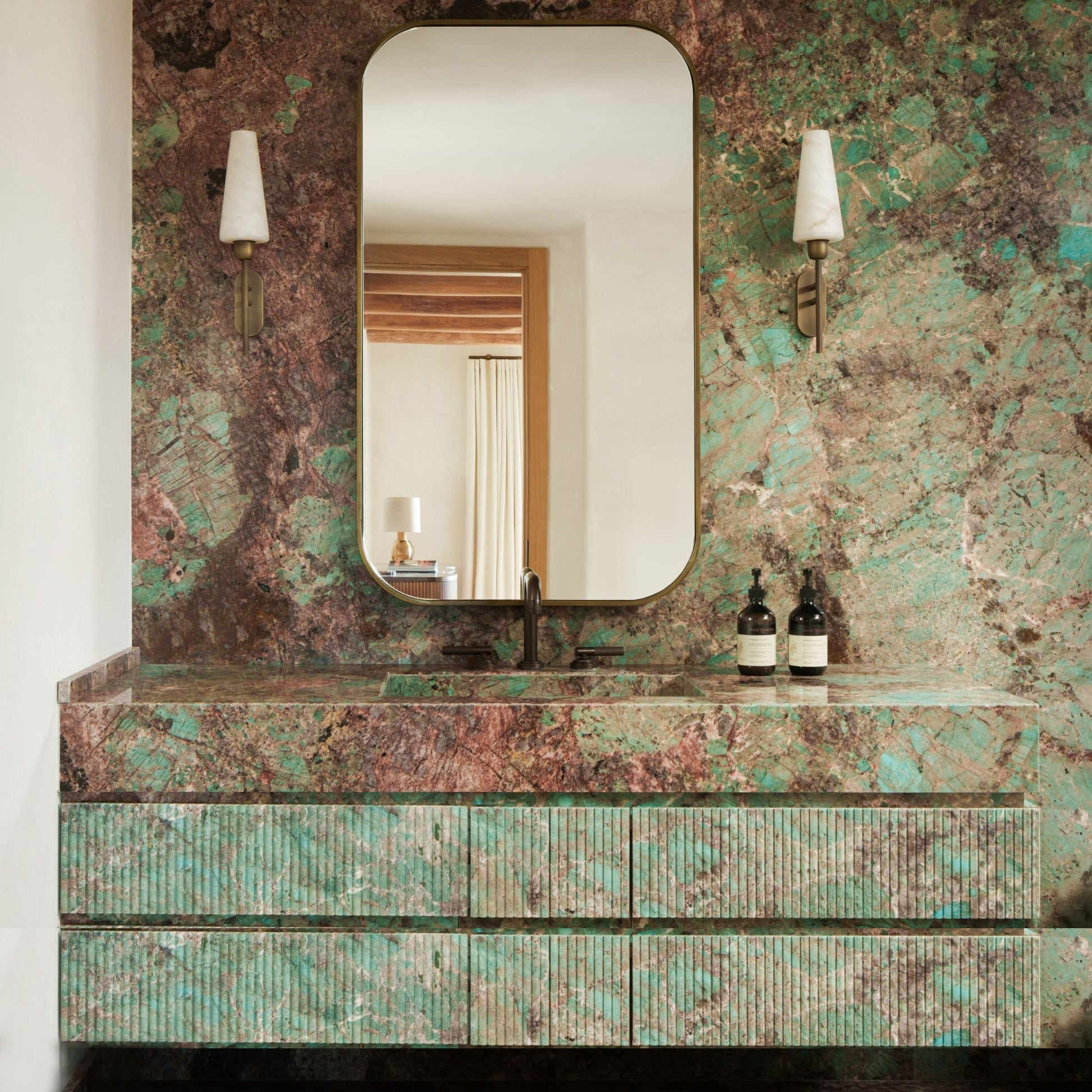 The Arras Wall Lamp illuminated, casting a warm, soft glow.