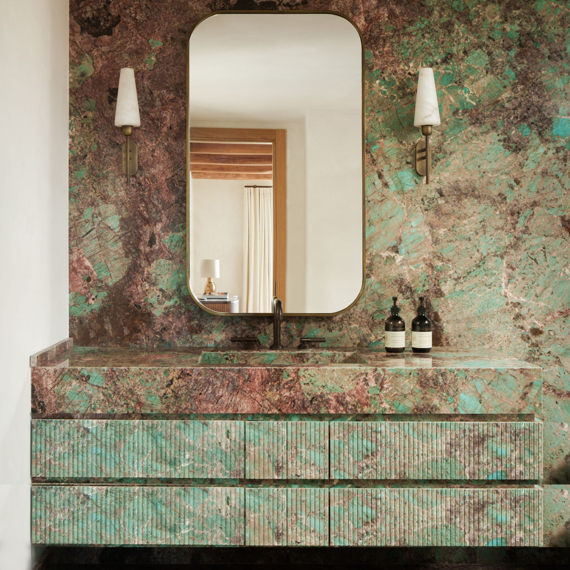The Arras Wall Lamp illuminated, casting a warm, soft glow.