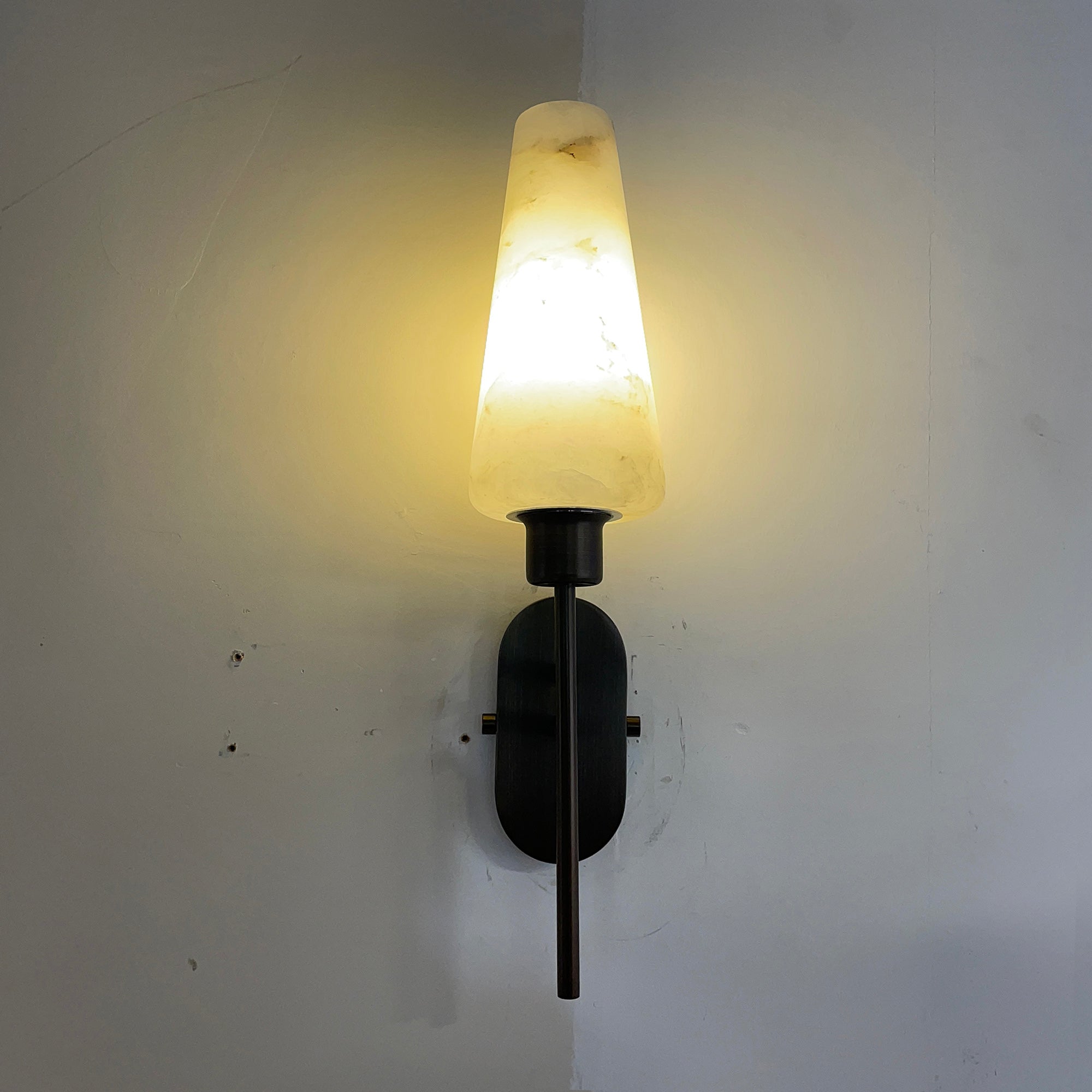 Close-up on the handcrafted metalwork of the lamp's arms.