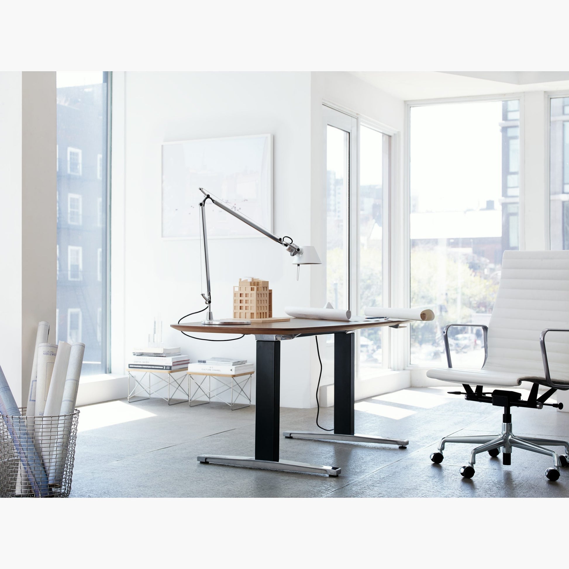 The lamp angled over architectural drawings on a drafting table.
