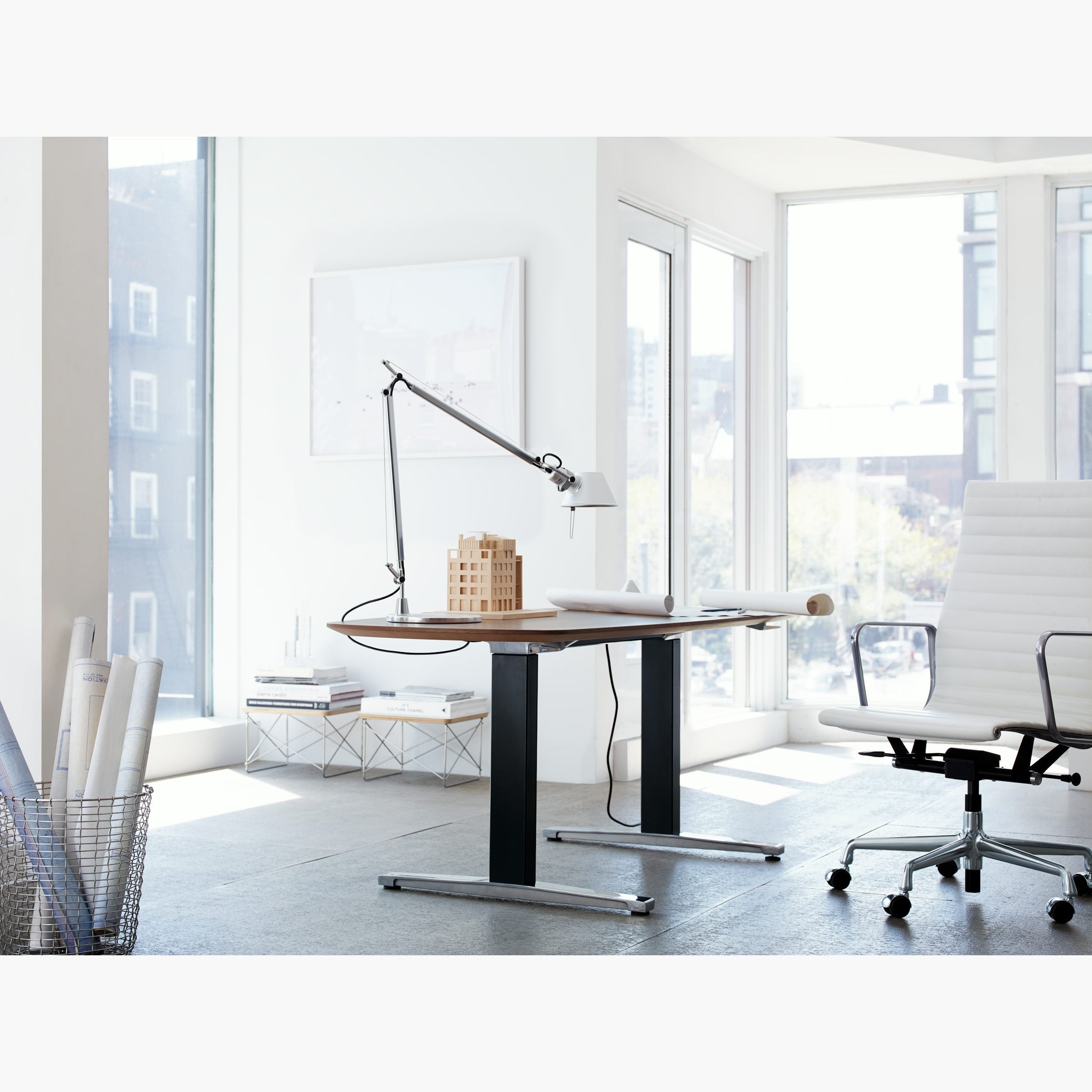 The lamp angled over architectural drawings on a drafting table.
