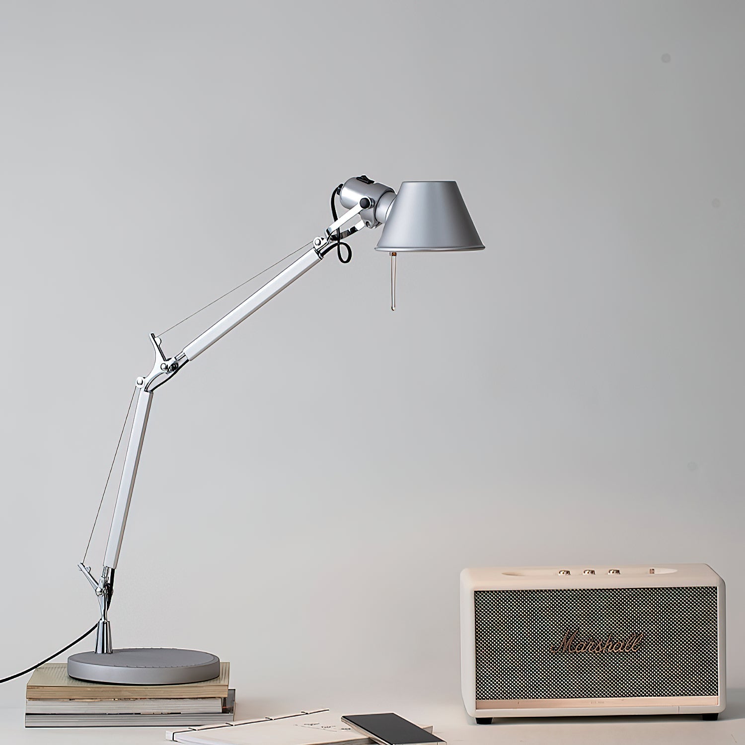 Close-up of the spring-balanced arm mechanism on the silver desk lamp.
