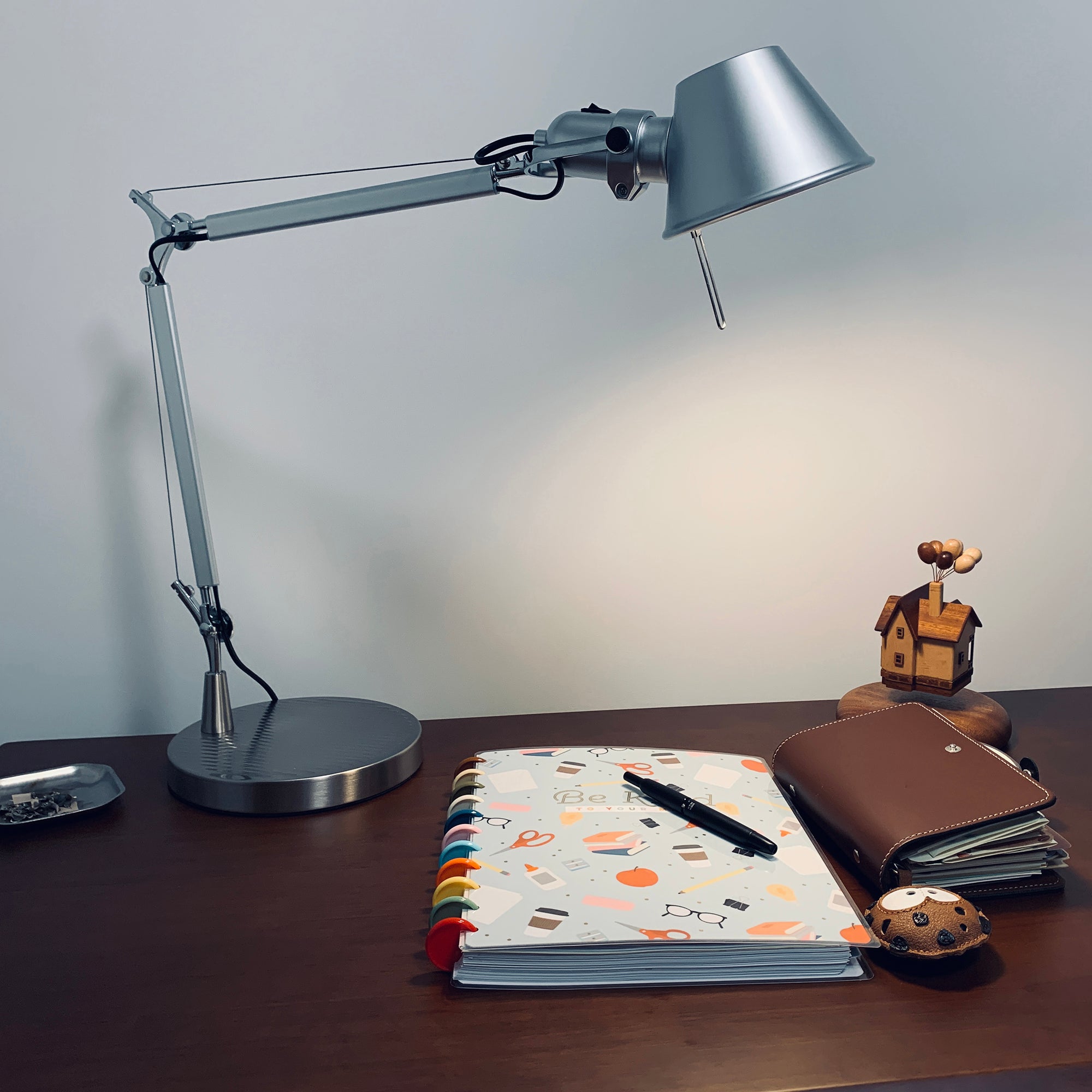 The desk lamp positioned on a home office desk, illuminating a laptop.