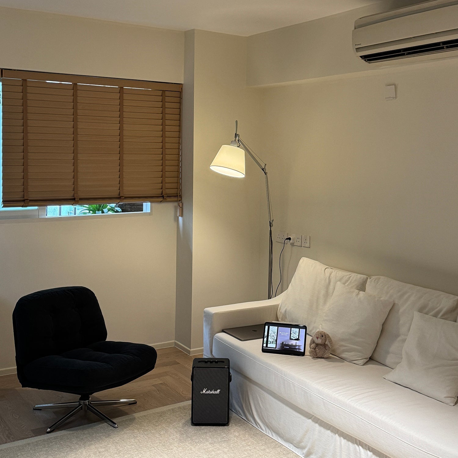 Beige Costanza Floor Lamp providing ambient light in a bedroom.