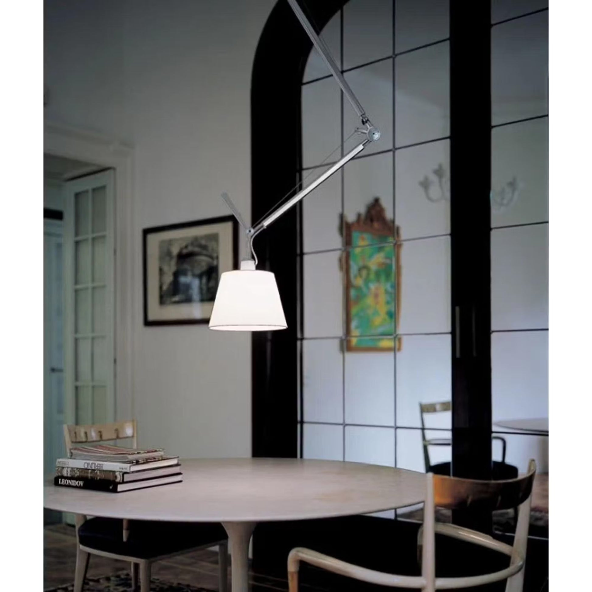 The two-head lamp illuminating a long conference table.