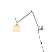 Costanza plug-in swing-arm wall lamp in silver, extended over a modern sofa.