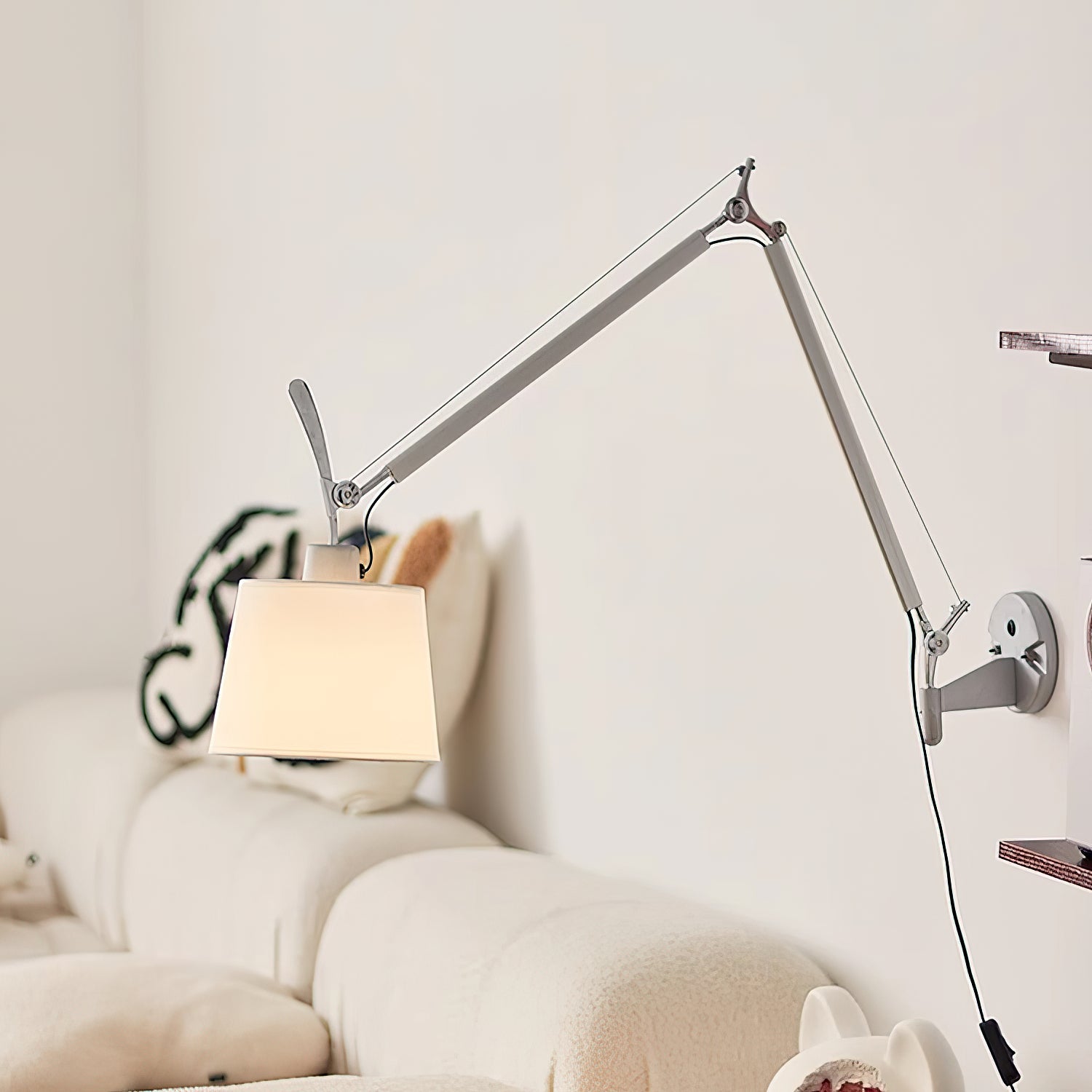 Close-up of the silver fabric drum shade on the Costanza wall lamp.