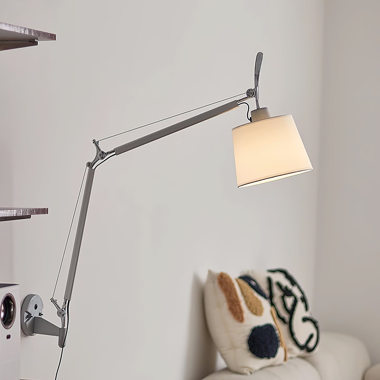 Costanza wall lamp in white with a white fabric shade against a light wall.