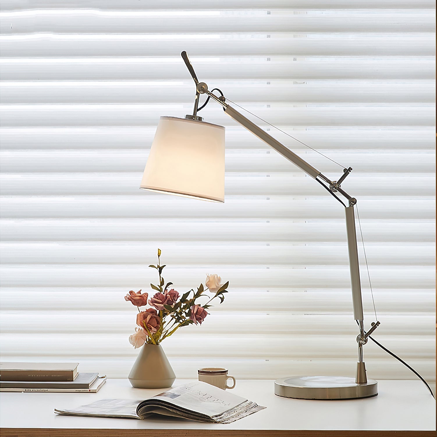 The Costanza Table Lamp illuminated, casting a warm, diffused light.