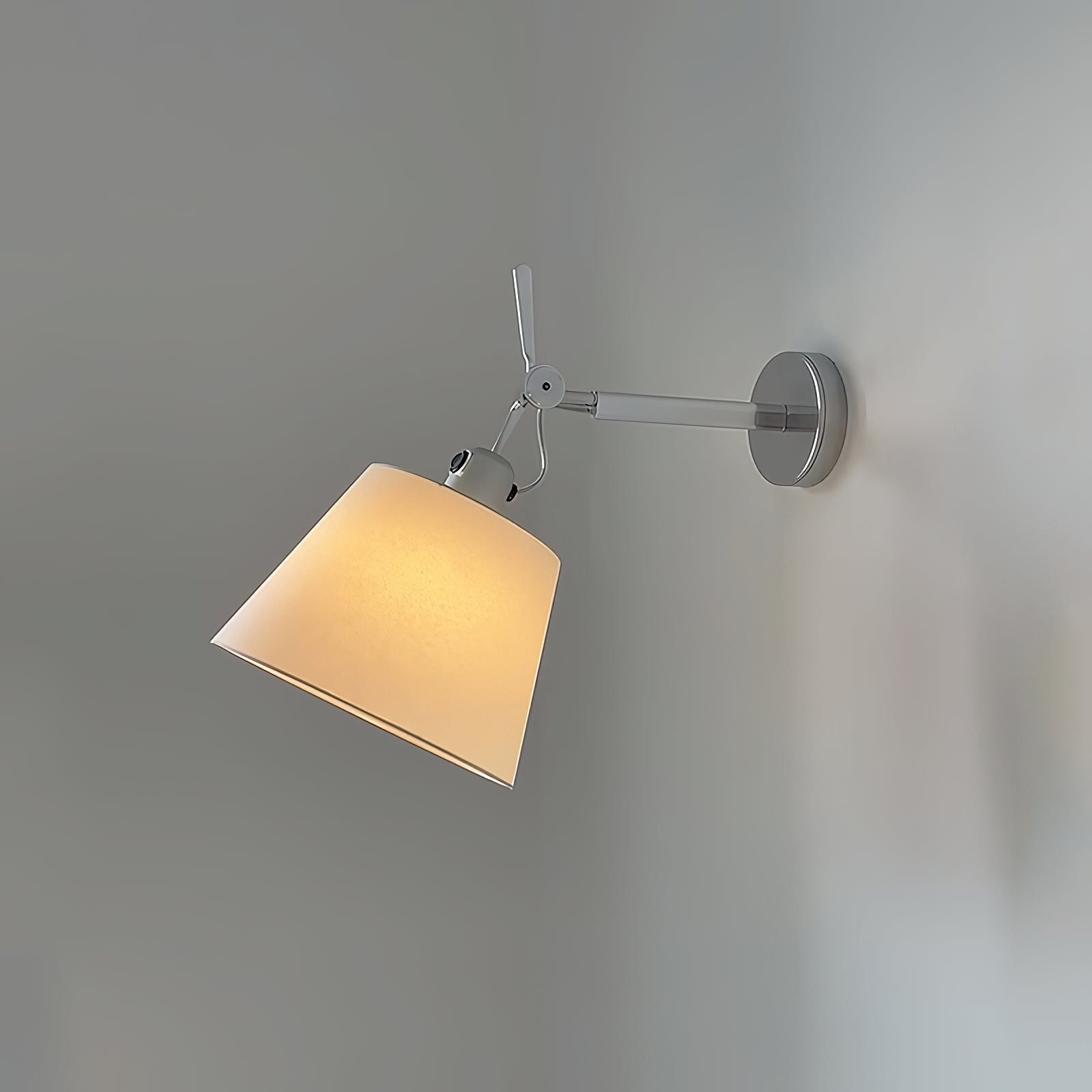The Costanza wall lamp installed in a modern bedroom as a bedside reading light.