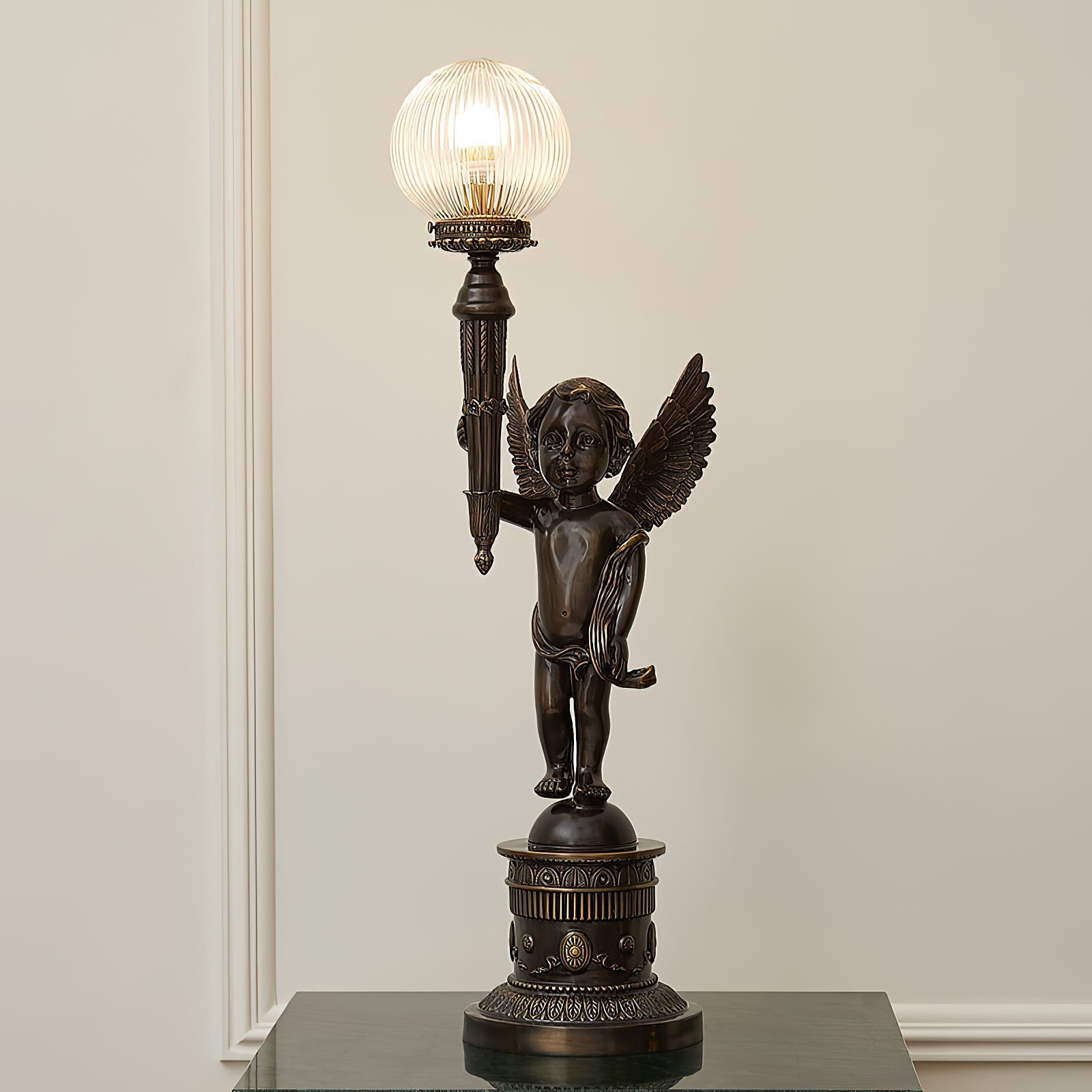 The lamp turned on, casting a warm glow through the clear glass shade.
