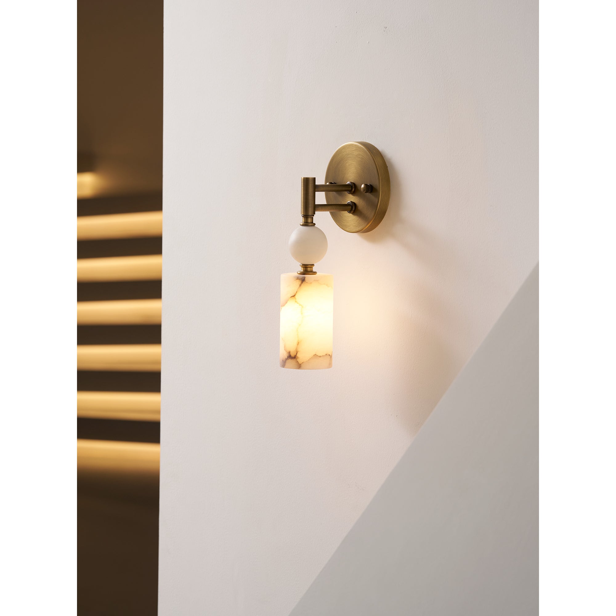 The Kingston Marble Wall Lamp illuminated, casting a soft, warm glow.