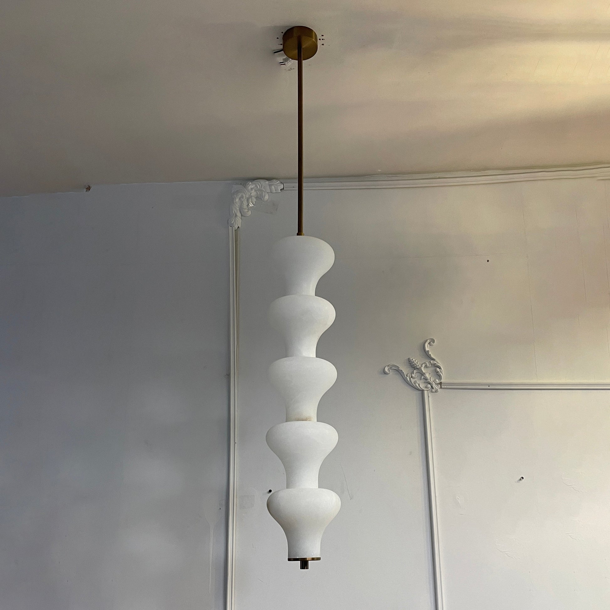 The alabaster pendant used as a bedside light in a minimalist bedroom.