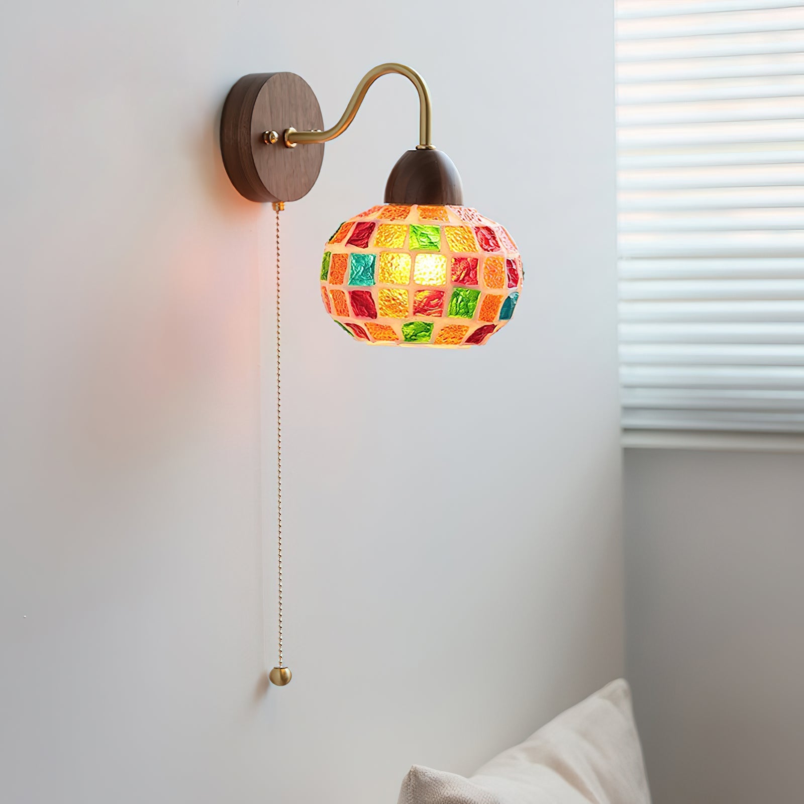 Close-up of the illuminated mosaic glass shade, showing vibrant red, orange, green, and blue tiles.
