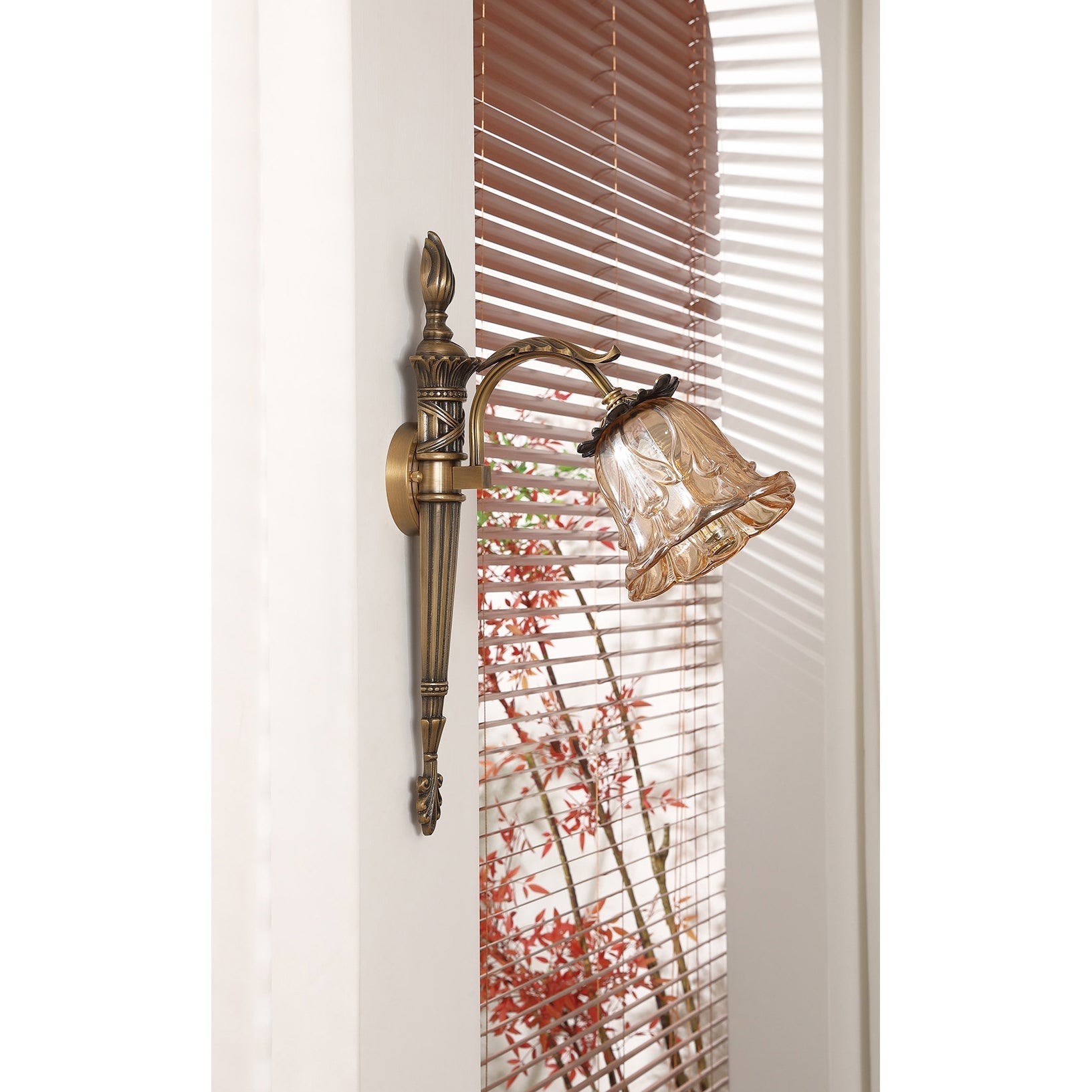 The warm, diffused light from the Benson Wall Lamp's amber shade.