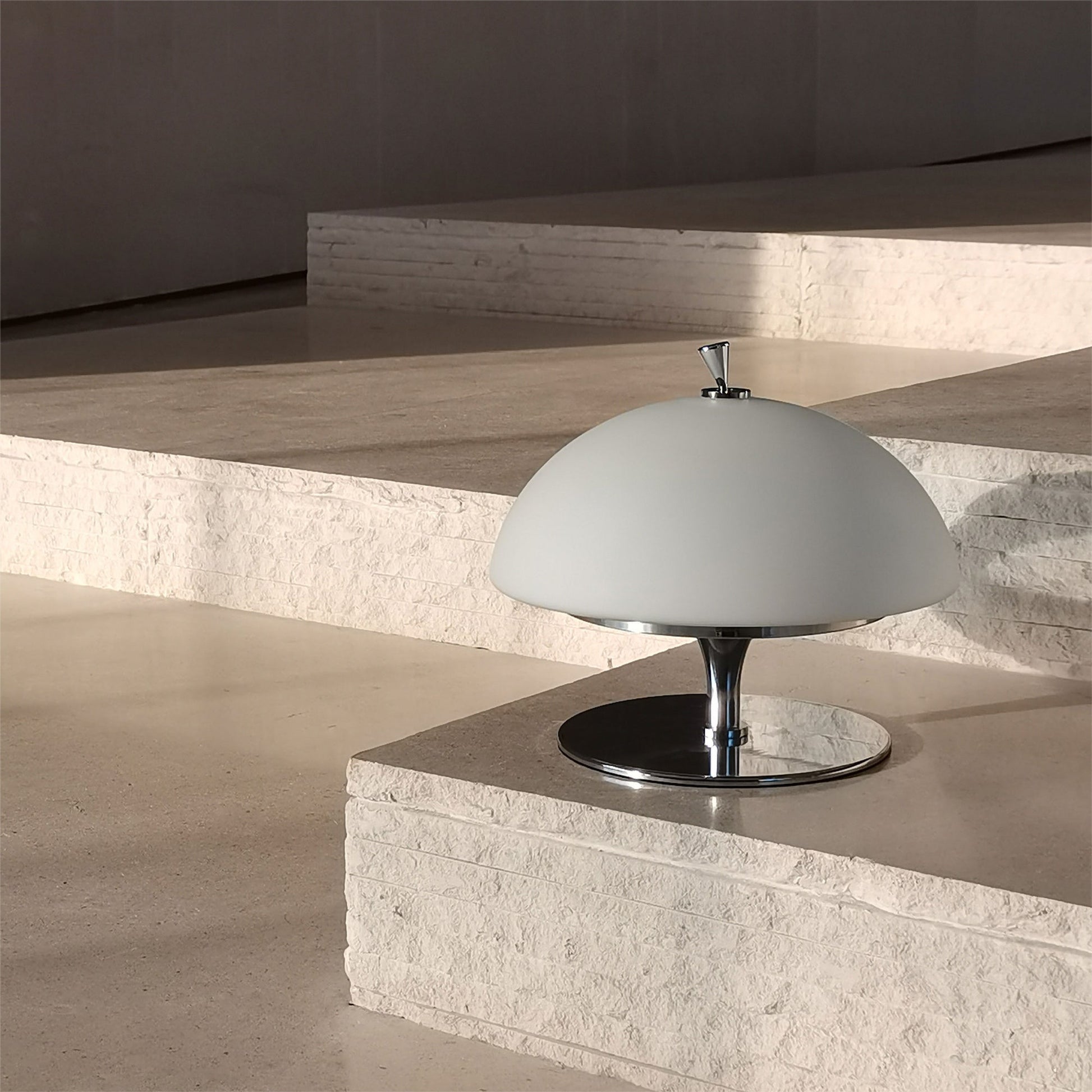 Side profile of the Beret Table Lamp, highlighting its white glass shade.