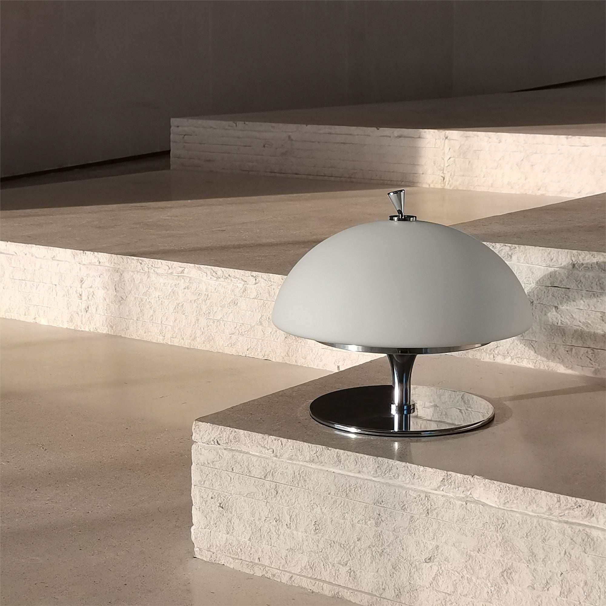 Side profile of the Beret Table Lamp, highlighting its white glass shade.