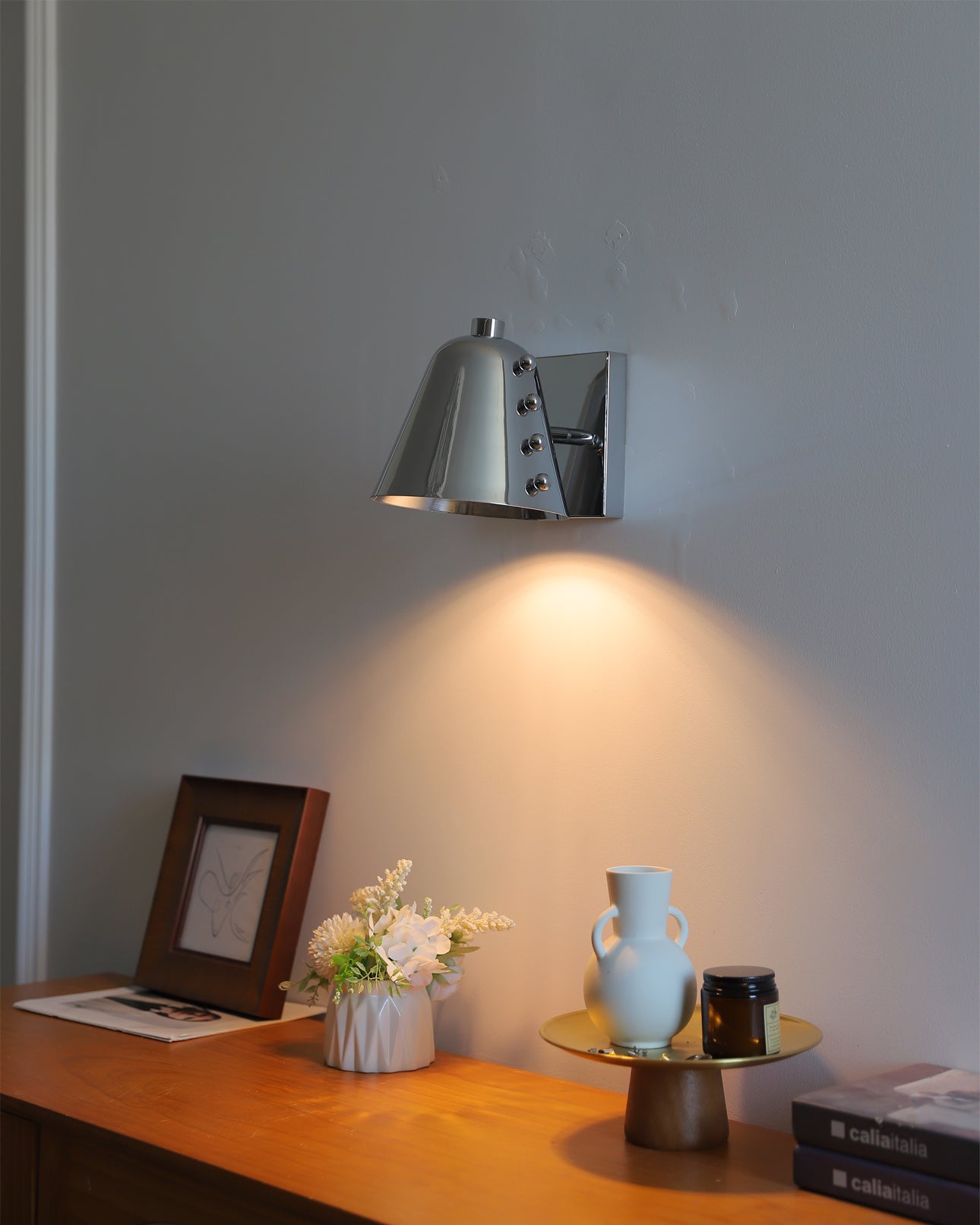 Bespoke wall lamp illuminating a piece of art.