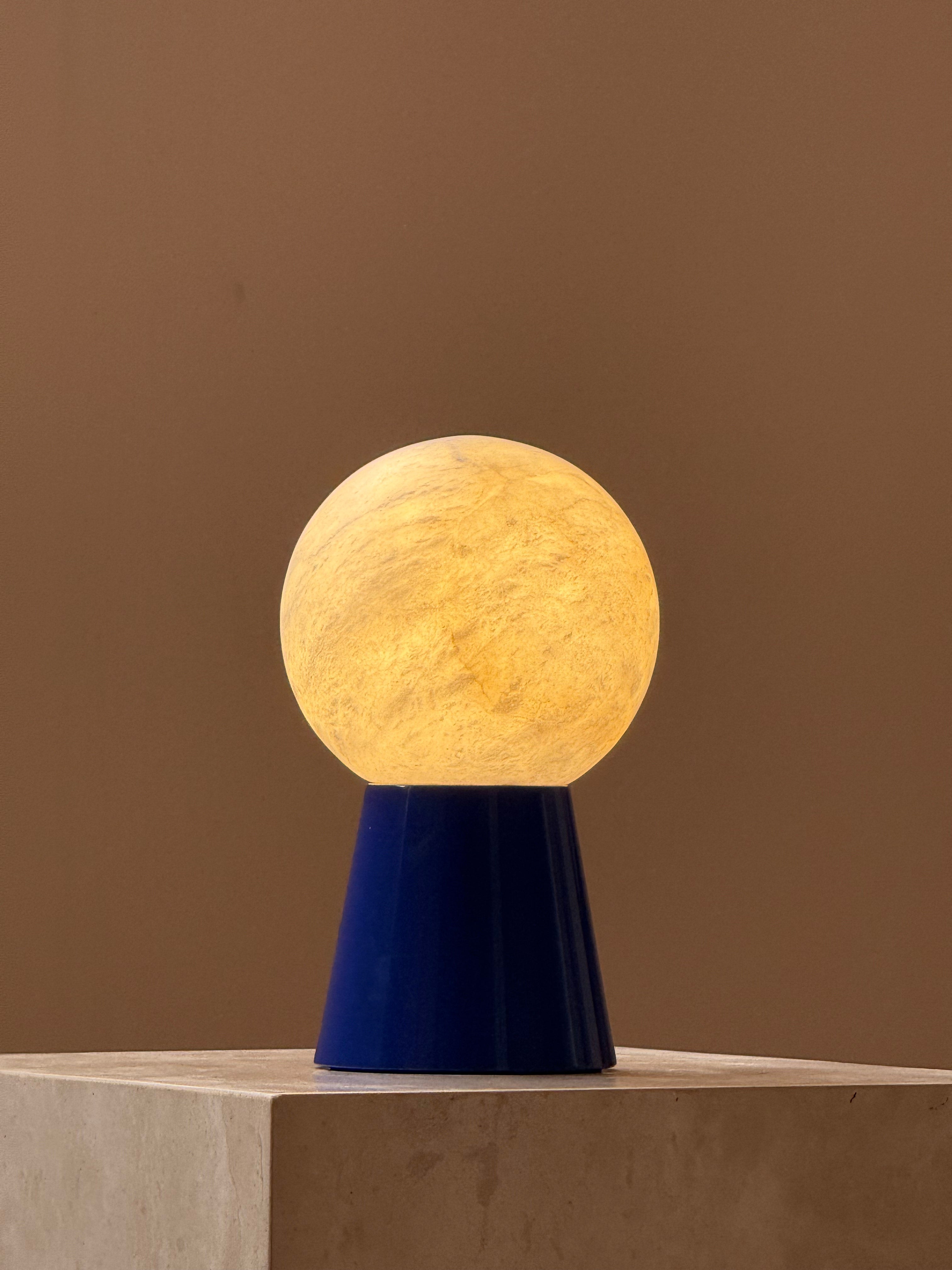 Lifestyle image featuring the Bilia Mini Table Lamp on a modern bookshelf.