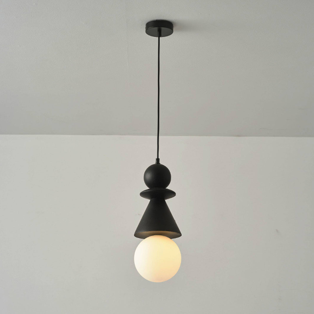 Bodie pendant light shown illuminated, casting a warm glow.