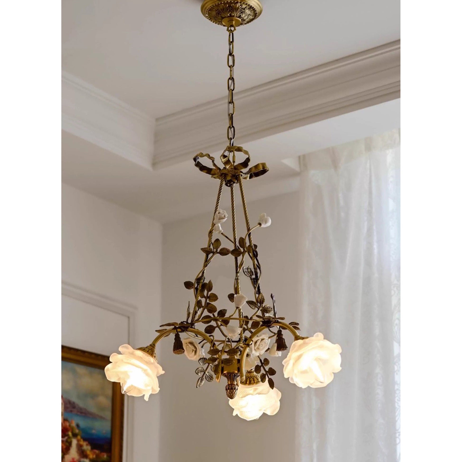 The chandelier hanging over a dining table, creating a romantic ambiance.
