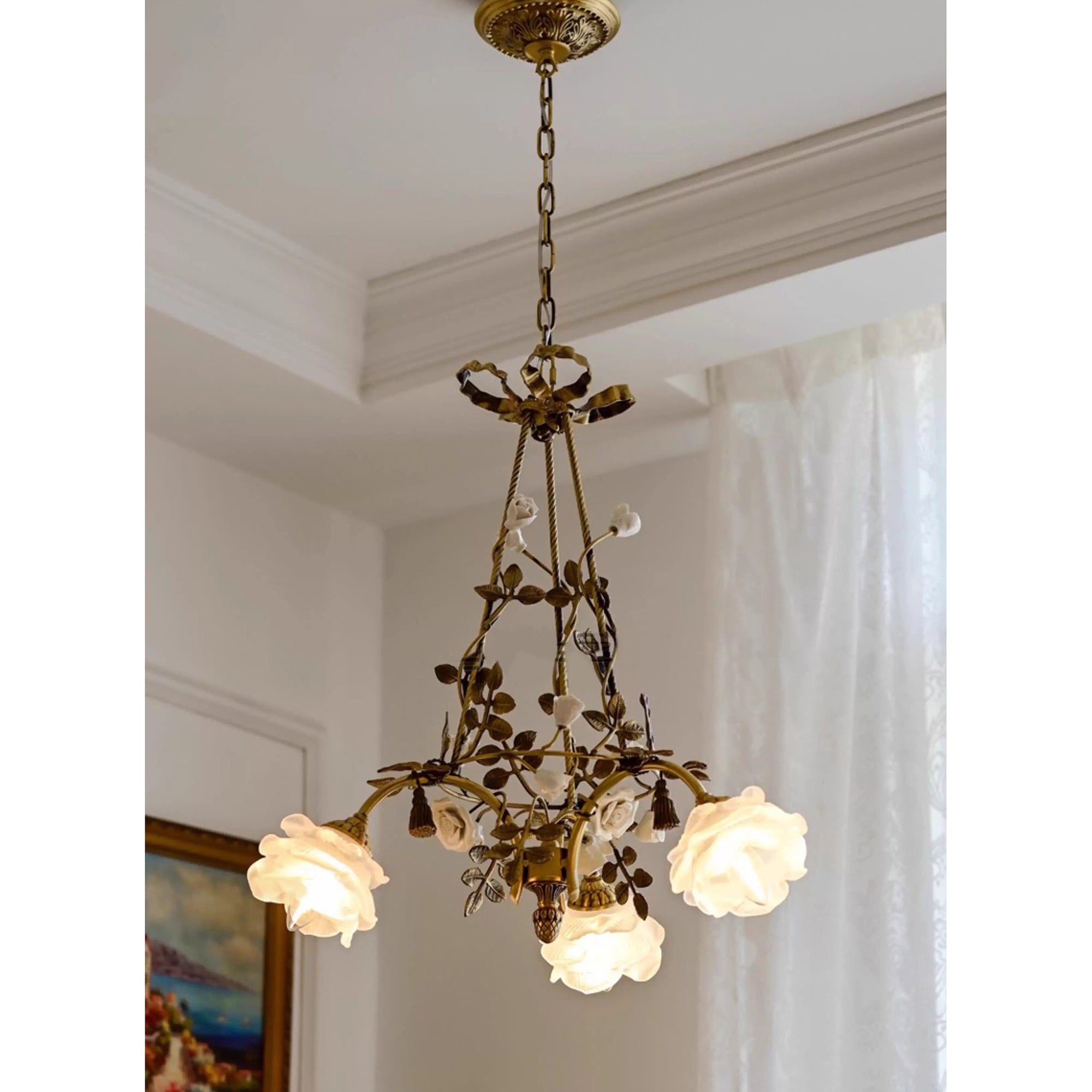 The chandelier hanging over a dining table, creating a romantic ambiance.