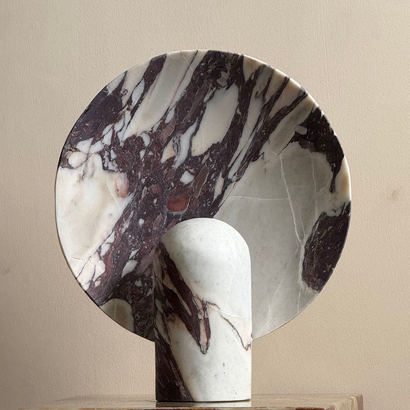 Lifestyle image of the white marble Fan Table Lamp on a nightstand.