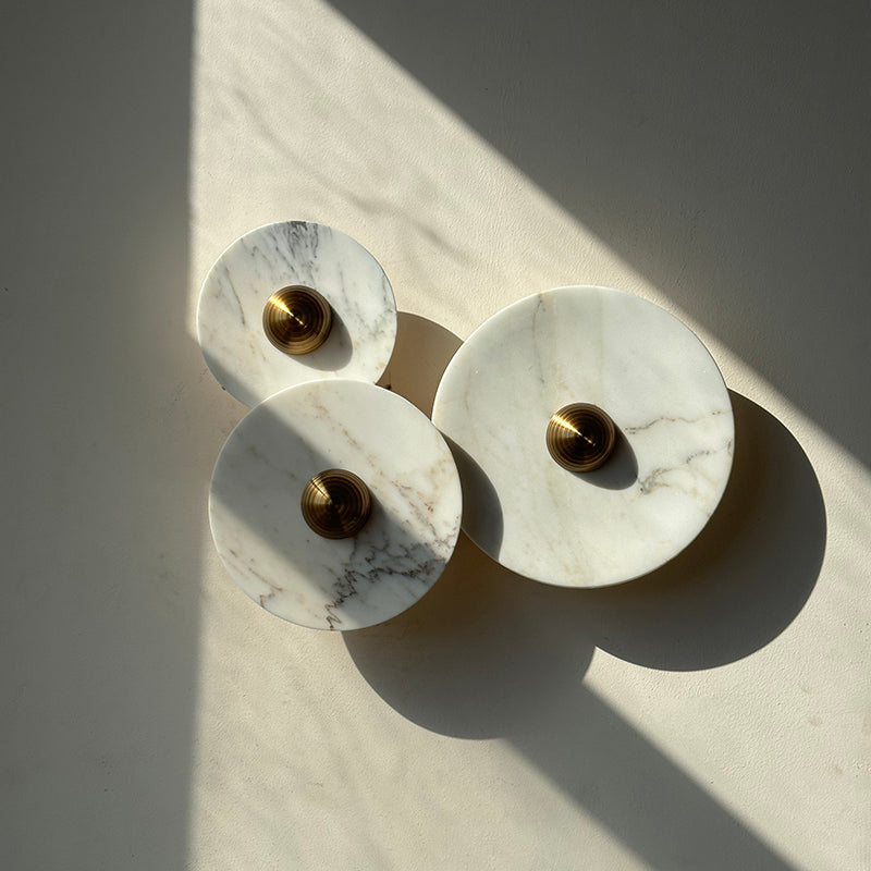 Angled view showcasing the design of the 3-head Calacatta marble sconce.