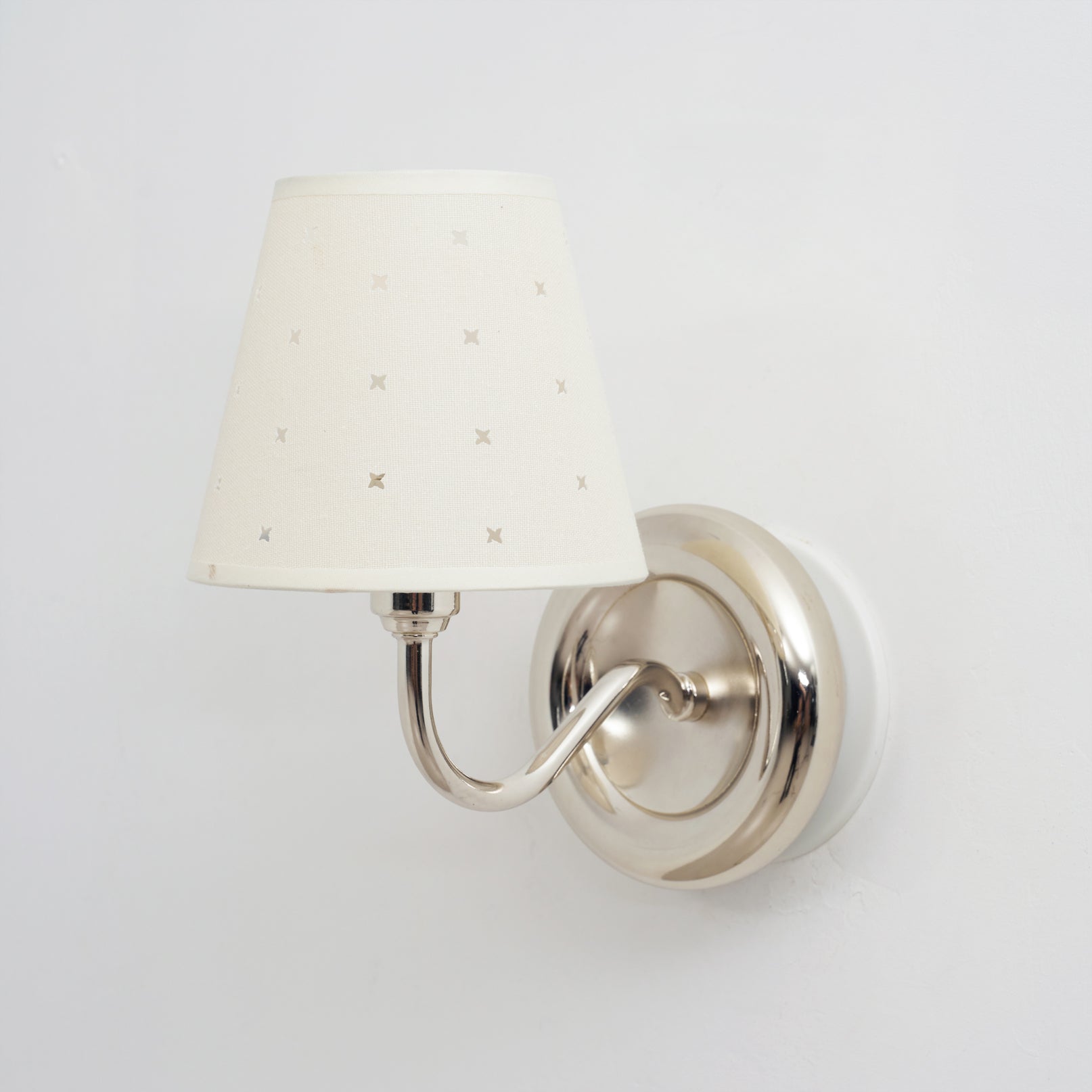 The round mounting plate of the Caleb sconce flush against a wall.