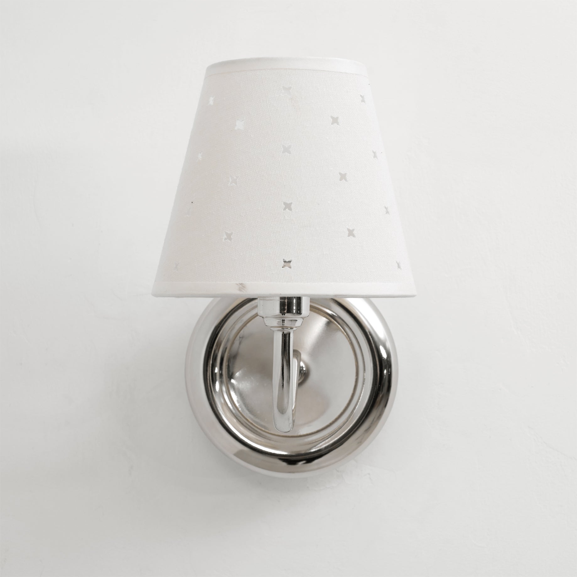 The gold Caleb Starburst Wall Sconce providing a warm accent against a dark wall.