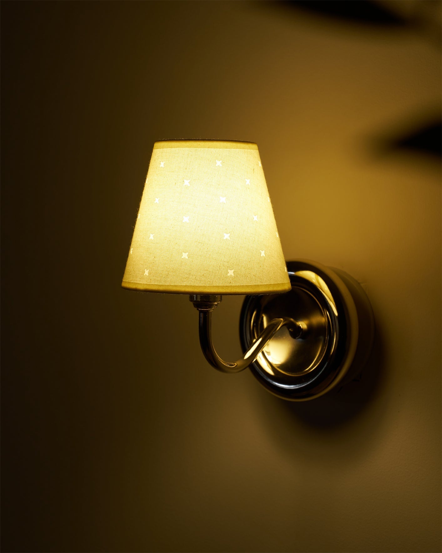 The white and chrome Caleb Starburst Wall Sconce in a bright, minimalist setting.