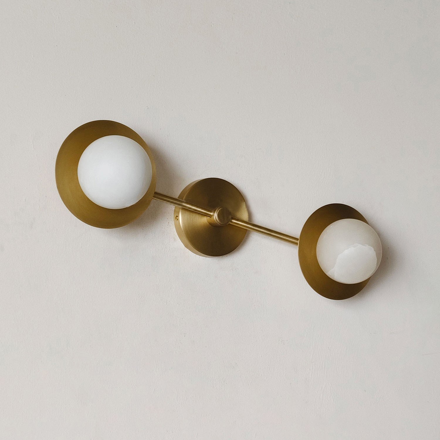 The Cara Wall Lamp shown from a side profile to display its depth and form.