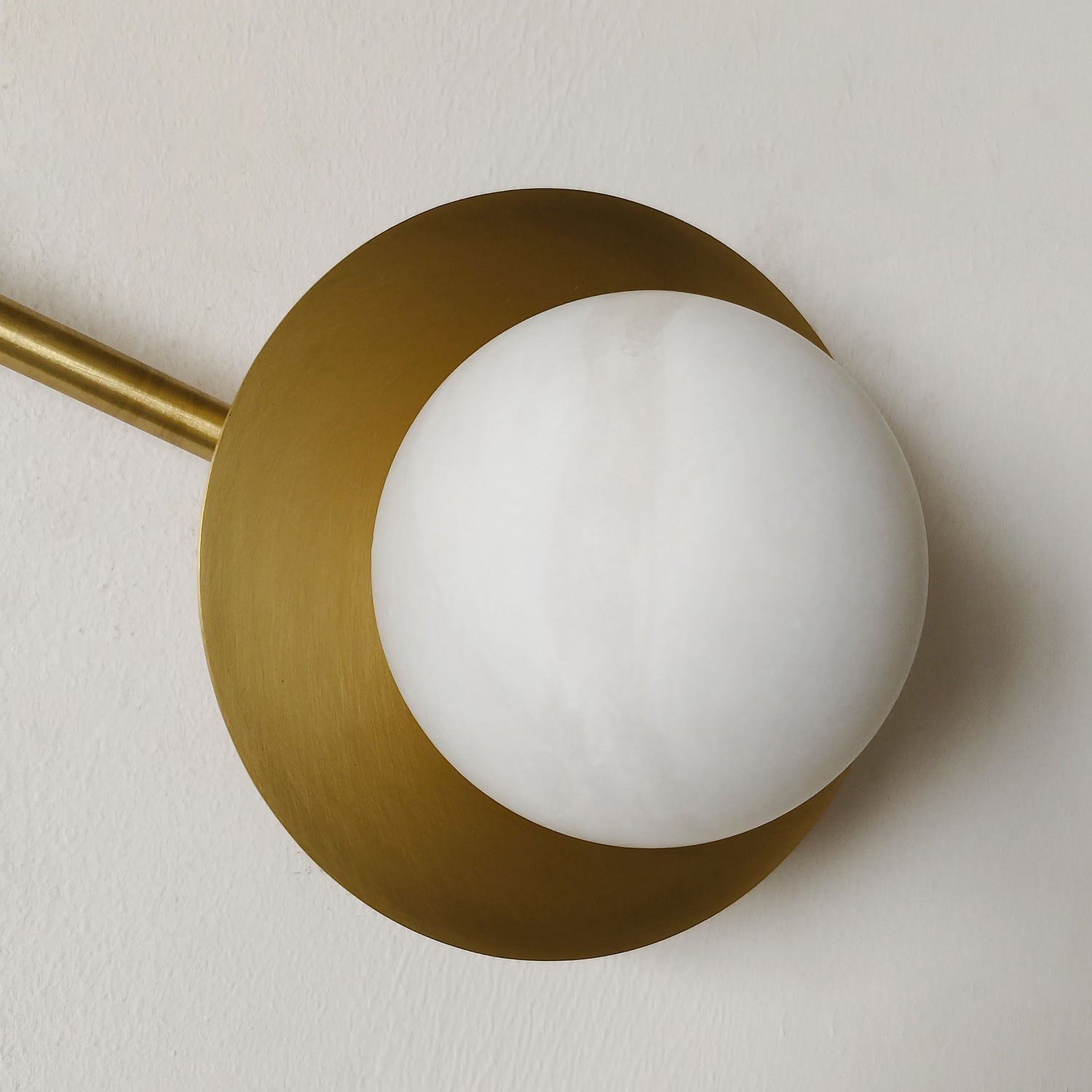 Unlit view of the wall lamp, emphasizing the material contrast between brass and alabaster.