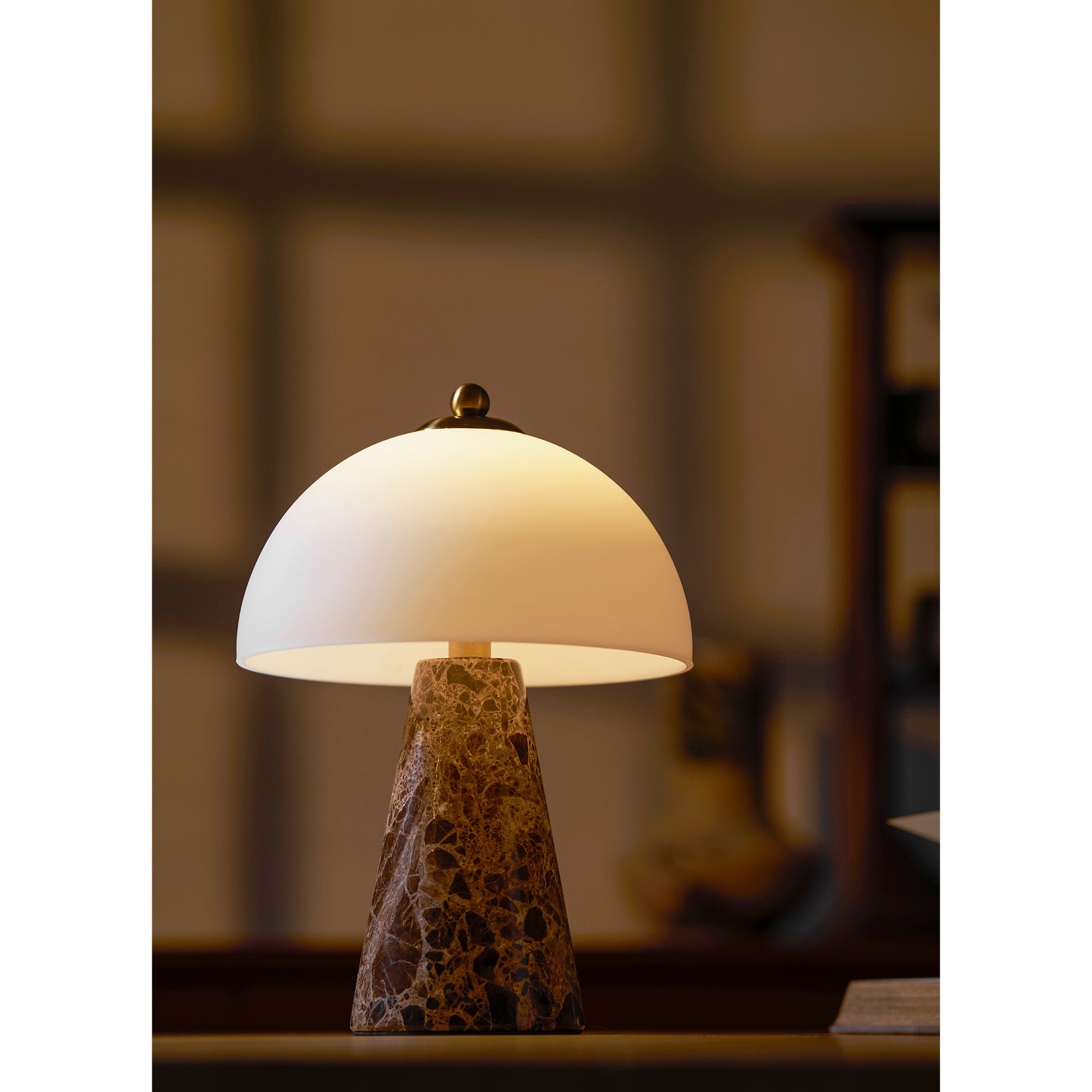 The white marble version of the Carme Table Lamp on a side table.