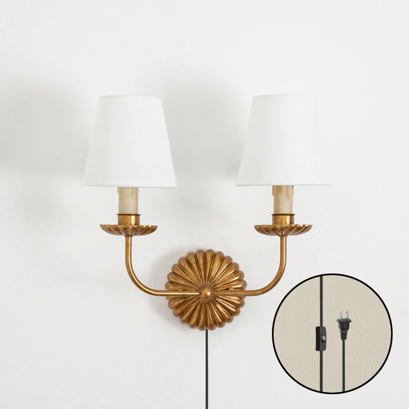 The antique gold sconce against a dark, moody wall color.