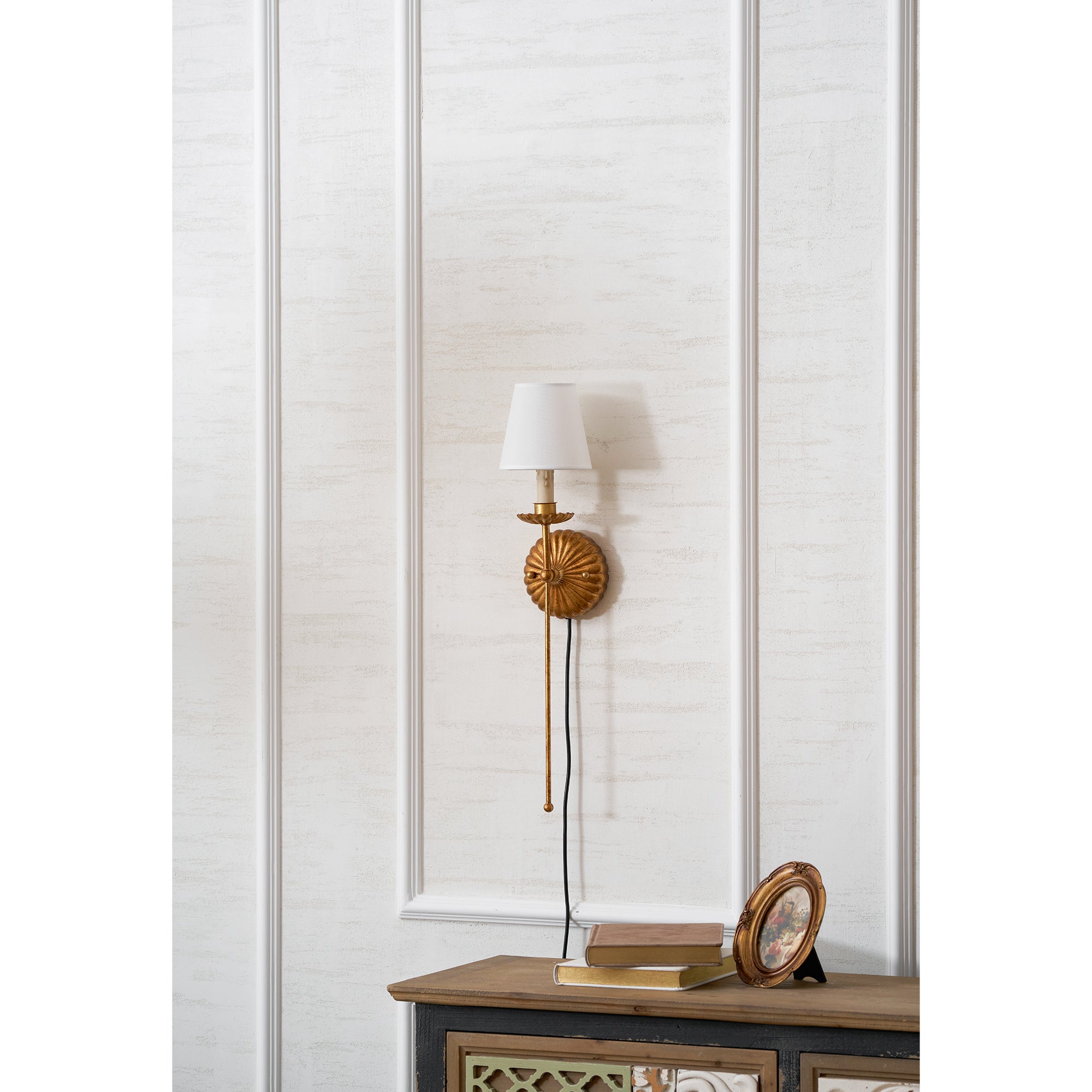 Antique gold wall sconce installed in a traditionally styled bedroom.