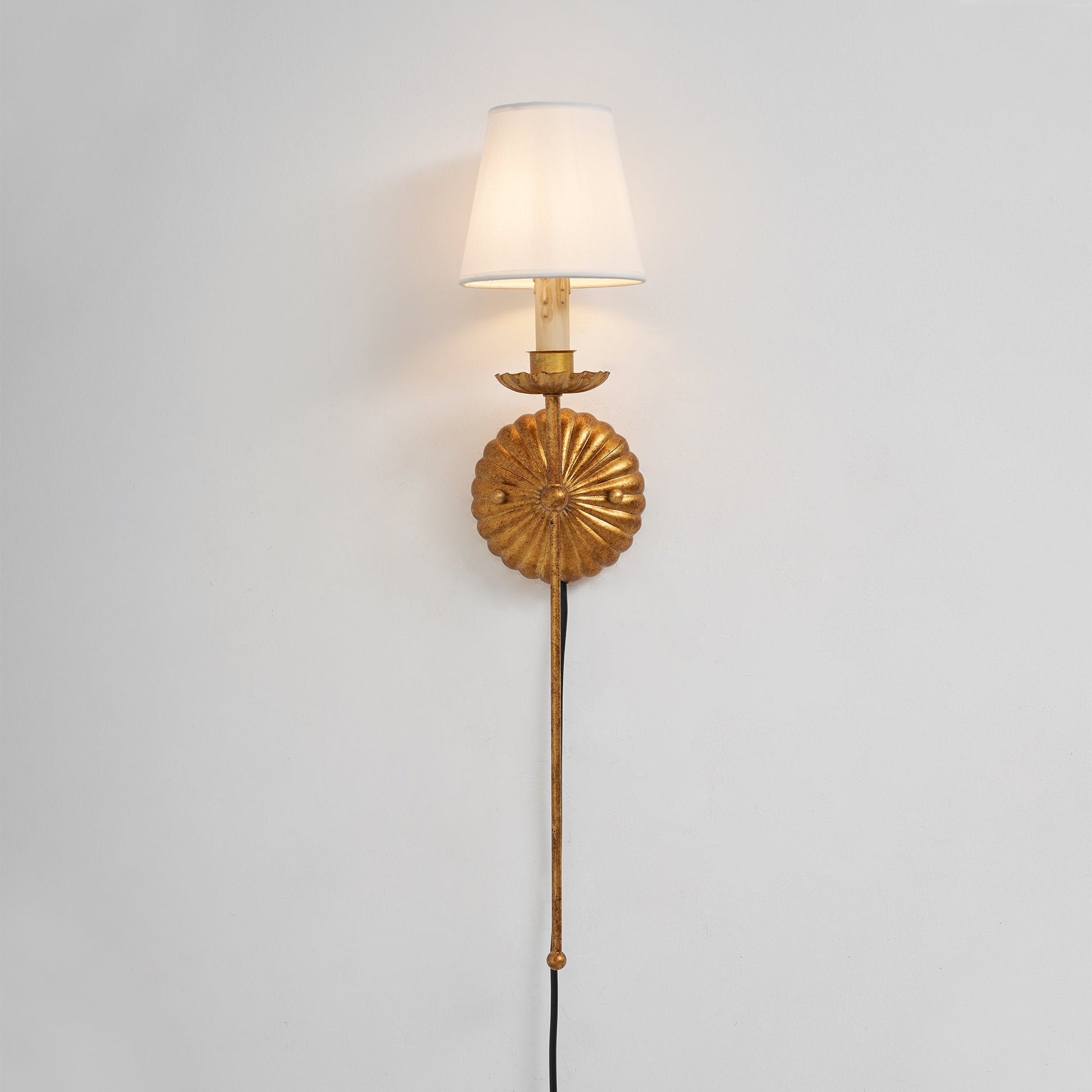 The wall sconce shown lit, casting a warm and inviting glow.