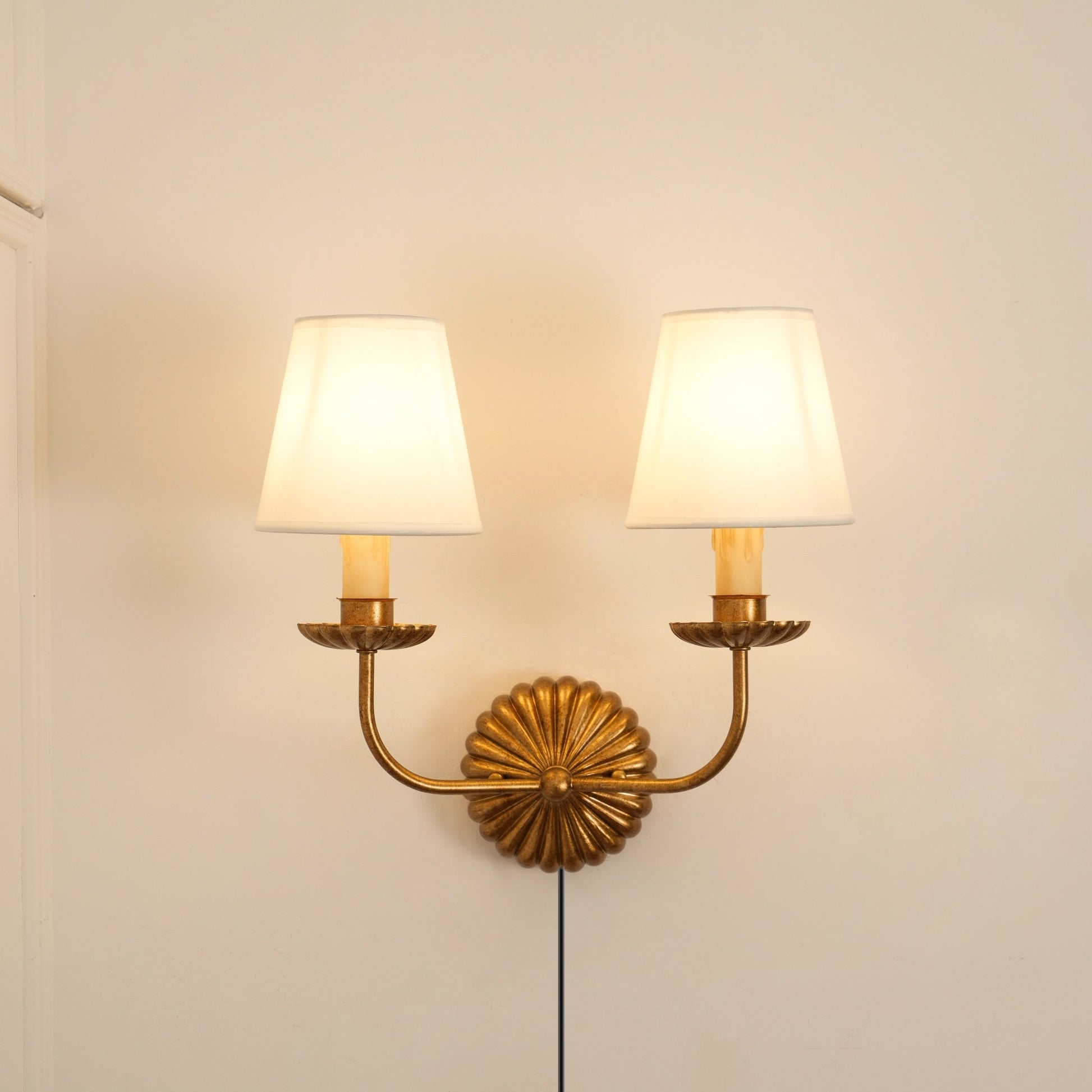 Lifestyle image of the double-arm sconce mounted above a console table.
